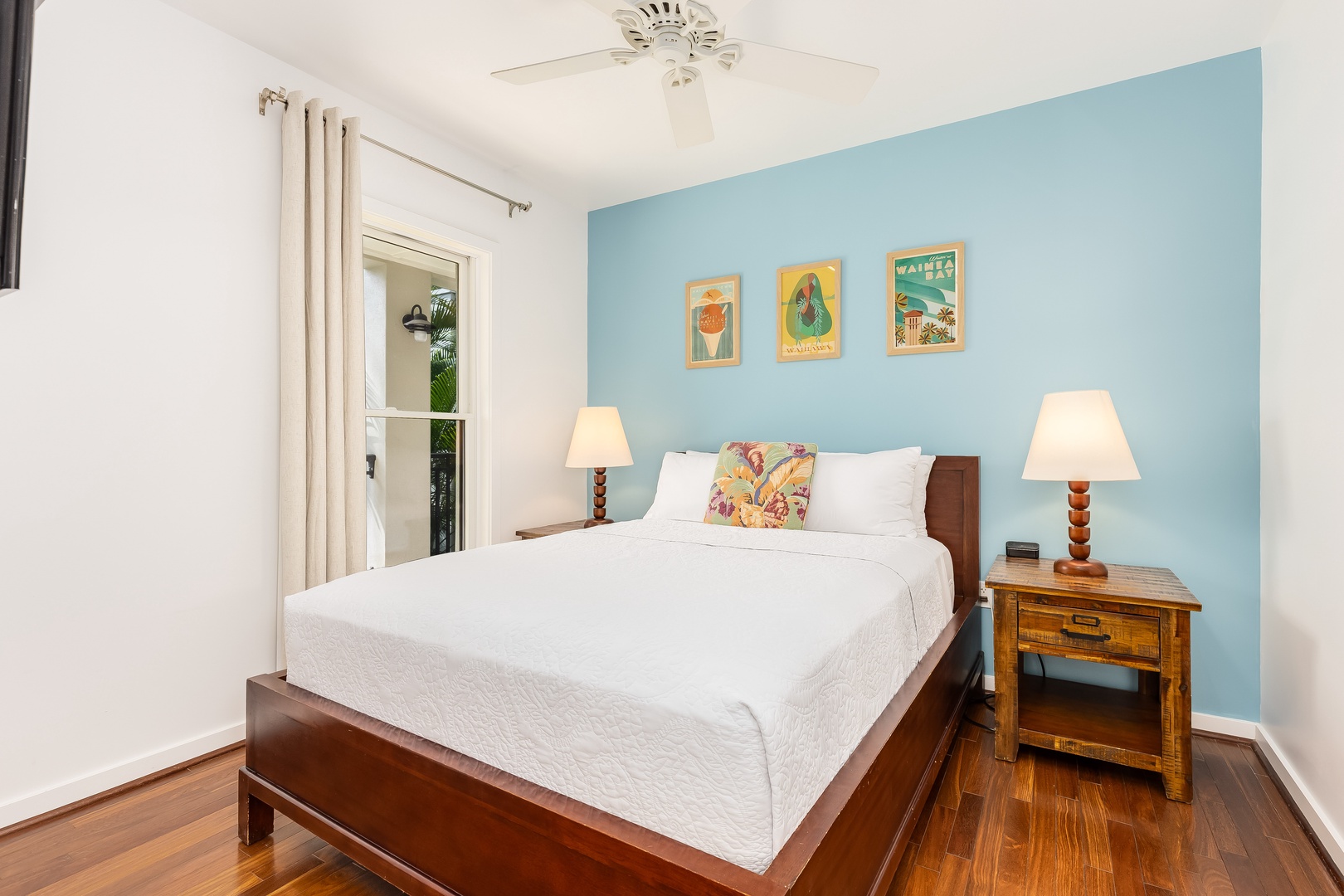Kahuku Vacation Rentals, Turtle Bay Villas 209 - Drift off peacefully in your serene bedroom, where tropical artwork and soothing blue walls create the perfect coastal retreat atmosphere.