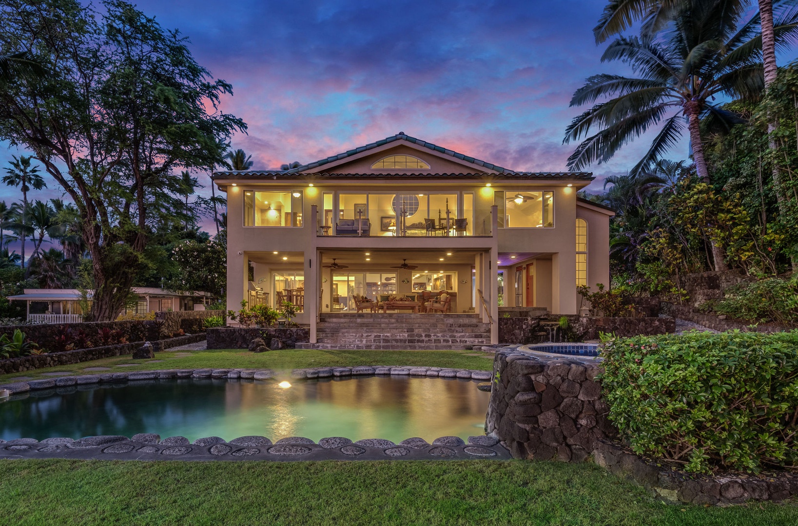 Kailua Kona Vacation Rentals, Kona Beach Bungalows** - Modern two-story villa surrounded by tropical palms and lush landscaping, featuring a private pool and stunning twilight atmosphere.