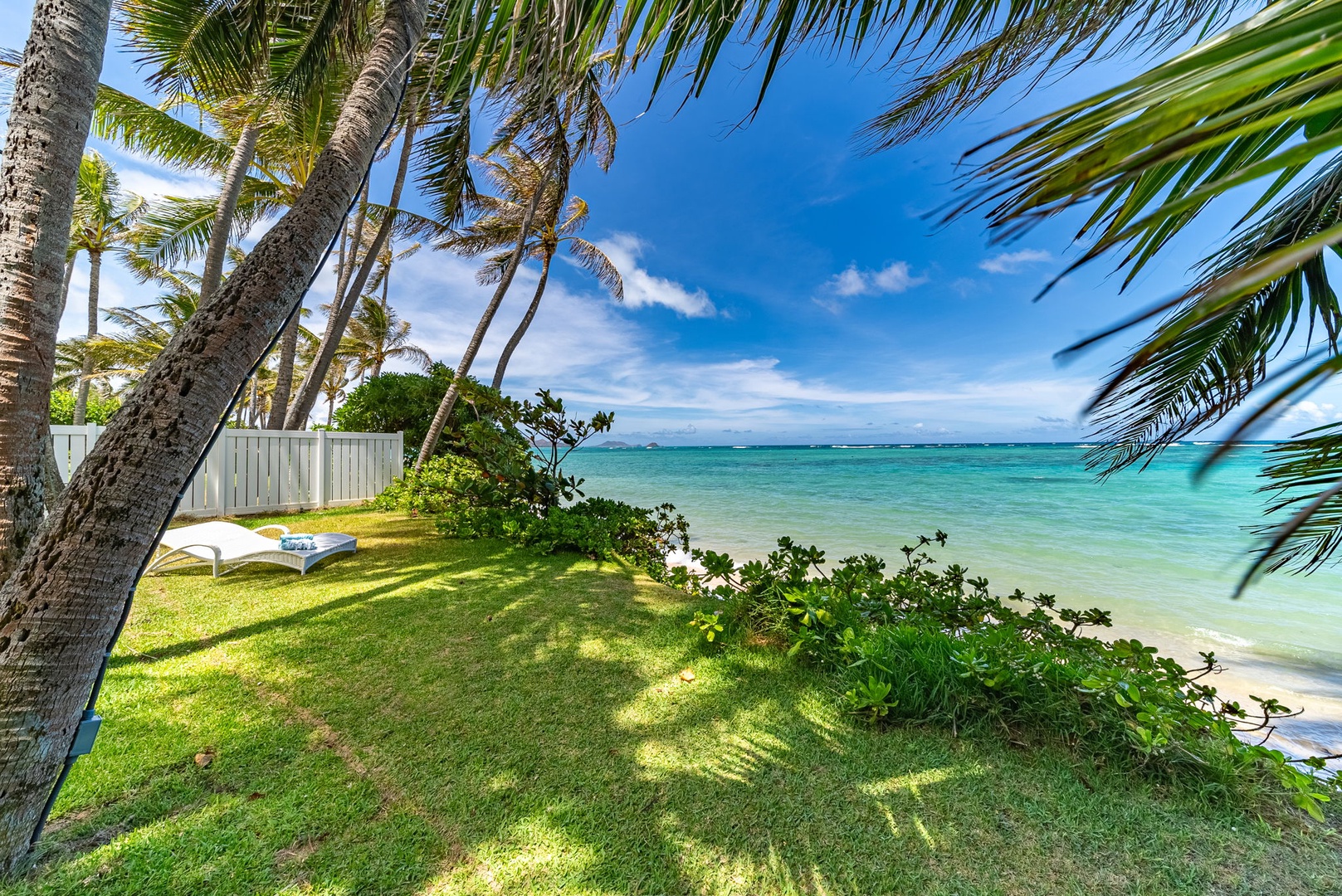 Waimanalo Vacation Rentals, Mana Kai at Waimanalo - Relax on the chaise lounge amidst a lush grassy expanse, with the luxurious home and majestic mountains framing the perfect backdrop.