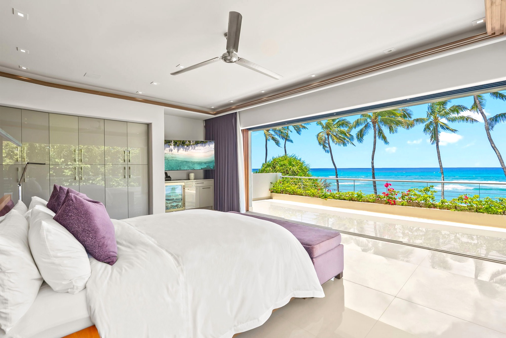 Honolulu Vacation Rentals, Diamond Head Beachfront Estate - Wake up to paradise in this elegant bedroom, where floor-to-ceiling glass doors frame stunning ocean views and swaying palms. Your private retreat features a plush king bed and direct access to a sun-drenched terrace overlooking turquoise waters.