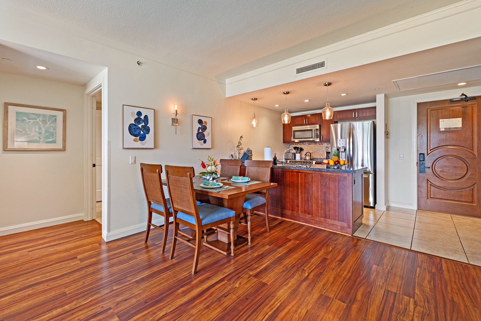 Lahaina Vacation Rentals, Honua Kai Konea 206 - The open-concept dining and kitchen area features rich hardwood floors and modern lighting, creating a warm and inviting space for meals and gatherings.