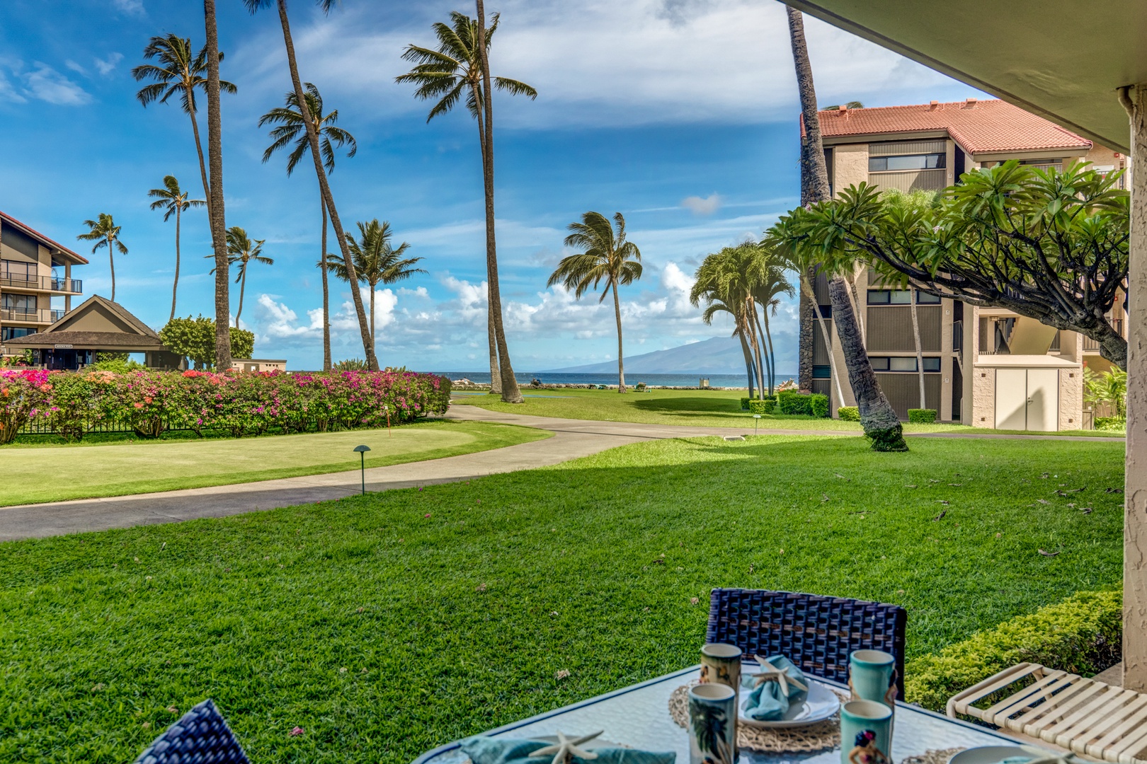 Lahaina Vacation Rentals, Papakea B-105 - Relax on the private lanai, enjoying your morning coffee with serene ocean views and the gentle breeze through the swaying palm trees.