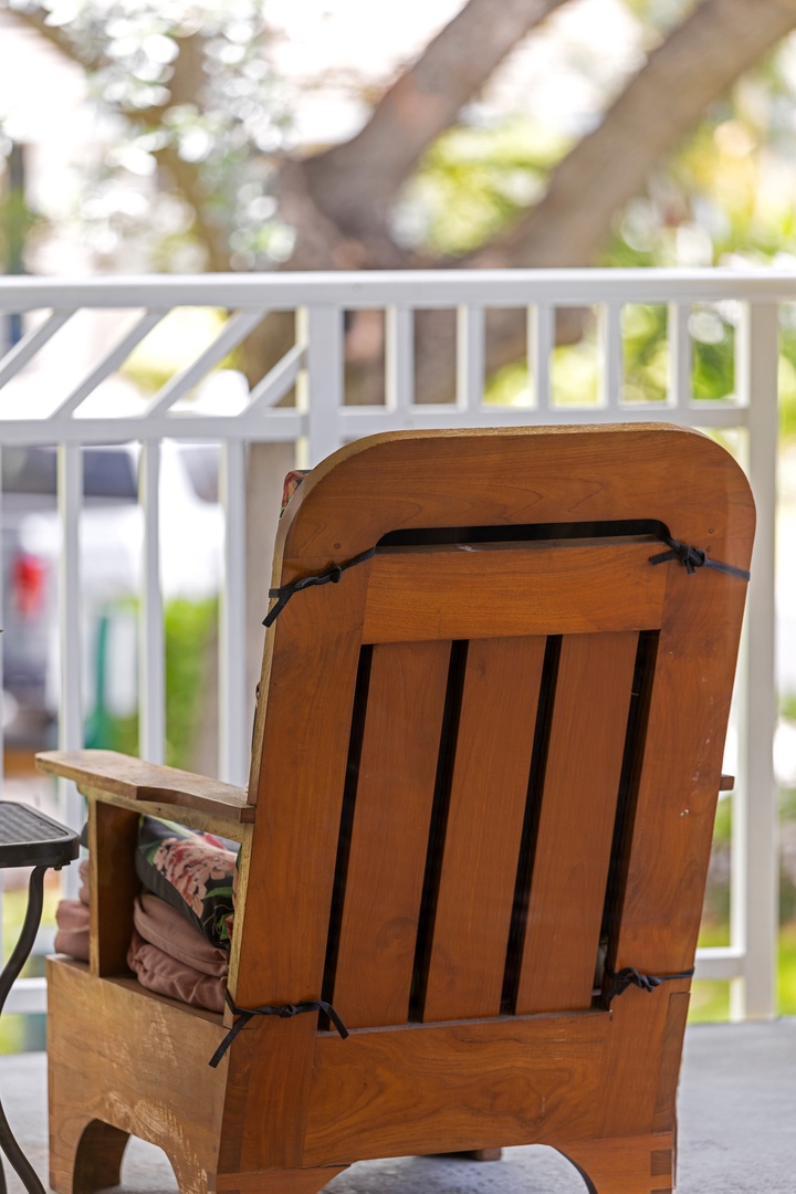 Kapolei Vacation Rentals, Ko Olina Kai 1105E - Hardwood rocking chair on a covered balcony overlooking peaceful green surroundings—your spot to unwind with a book or morning coffee.