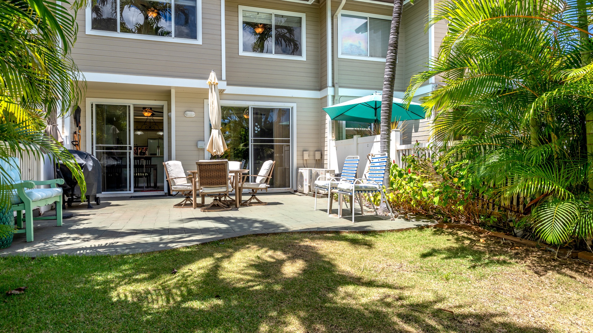 Kapolei Vacation Rentals, Fairways at Ko Olina 8G - Relax on your private lanai surrounded by lush tropical palms, with comfortable outdoor dining and lounge chairs perfect for sunny mornings.