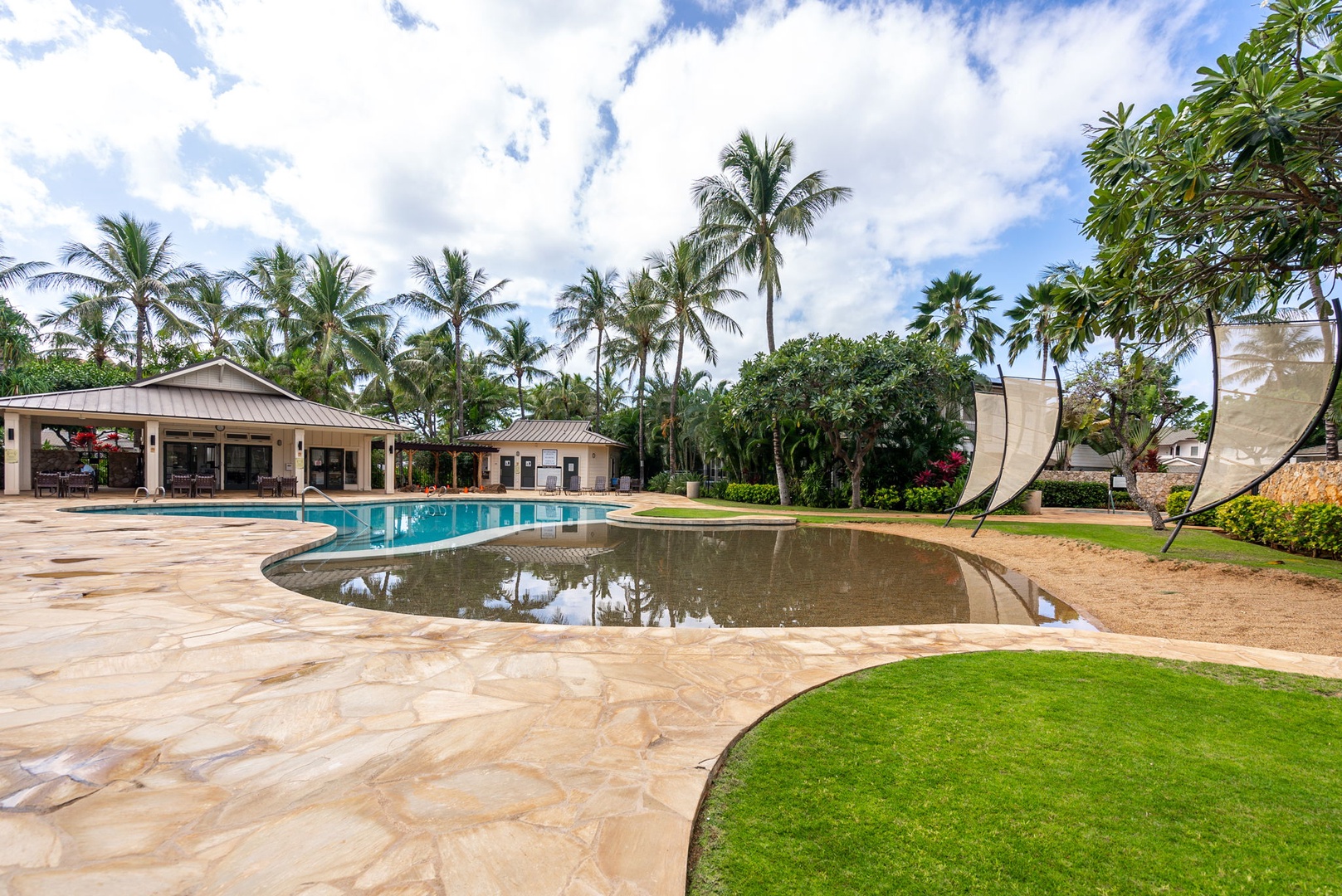 Kapolei Vacation Rentals, Coconut Plantation 1080-4 - The pool curves around a rock grotto with lawn stretching out beyond.