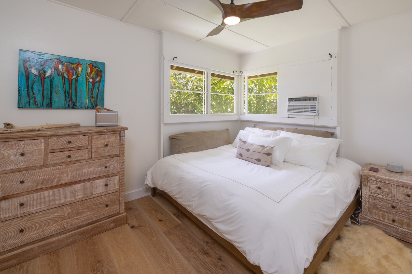 Kahuku Vacation Rentals, Hale Pellicano - The guest bedroom featuring a king-sized bed, window AC and garden views.