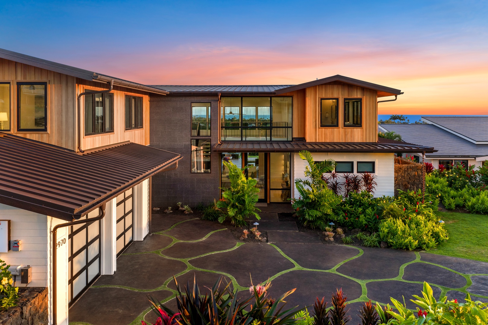 Koloa Vacation Rentals, Hale Laule'a at Kukui'ula - Modern tropical villa showcasing stunning architecture at sunset with lush landscaping and ocean views.