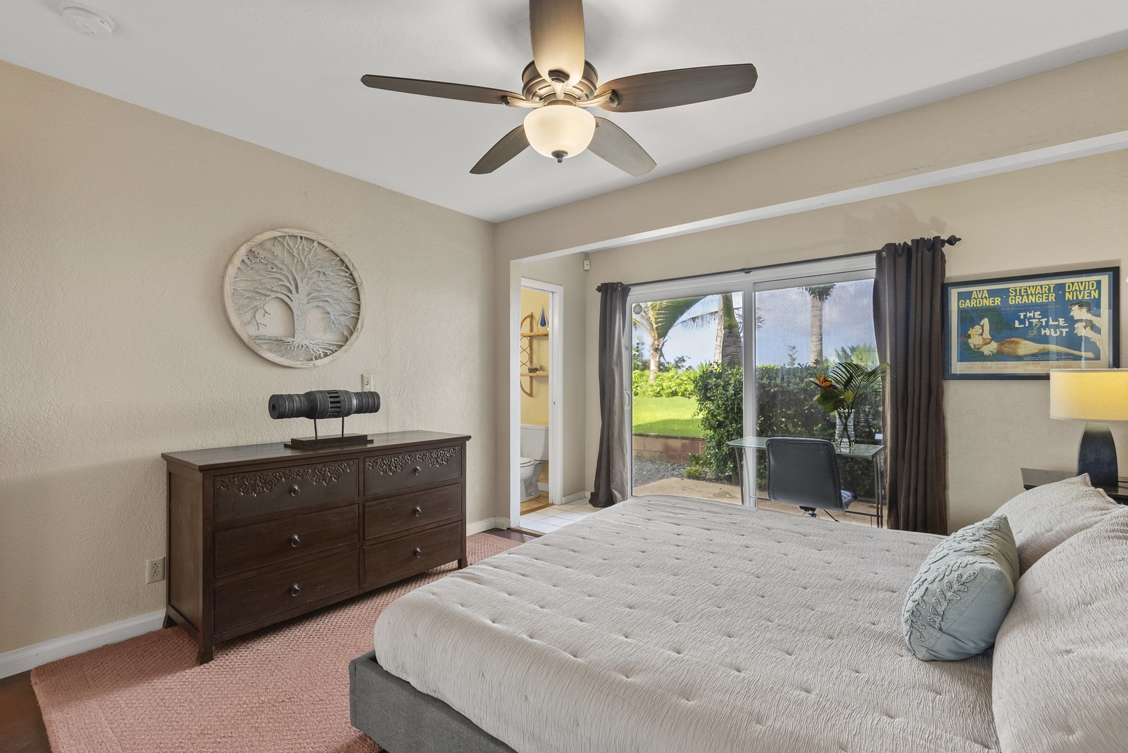 Haleiwa Vacation Rentals, North Shore Beachfront Retreat - Guest bedroom with a king-size bed, outdoor access, and peaceful garden views.