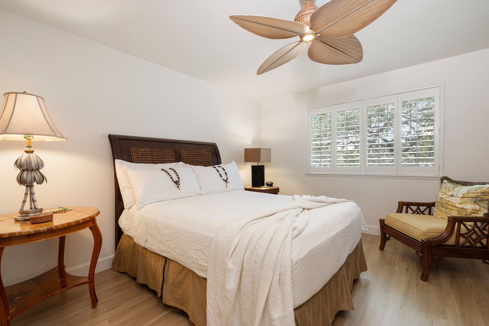 Kapolei Vacation Rentals, Ko Olina Kai 1105E - Sink into crisp white linens beneath a tropical-style fan. Your peaceful retreat features coastal-inspired décor, warm wood tones, and natural light from plantation shutters.