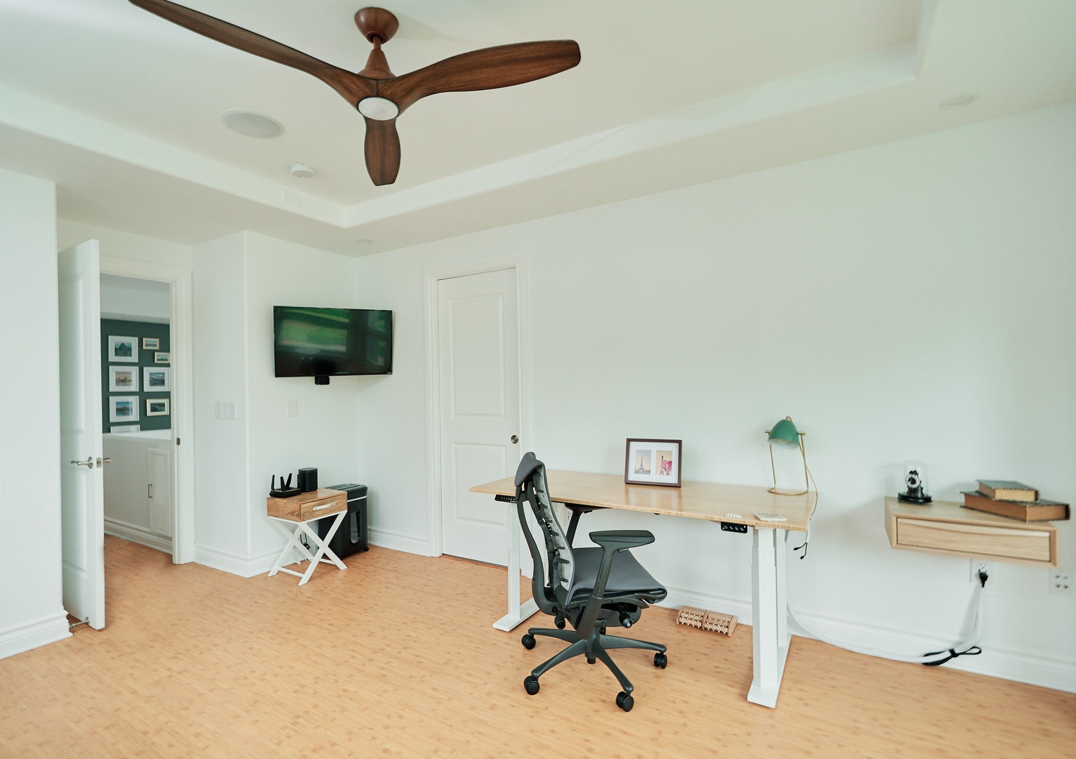 Princeville Vacation Rentals, Hale Kai - Focus and productivity flow naturally in your dedicated workspace, featuring an ergonomic desk, professional chair, and wall-mounted TV for comfortable remote work sessions.