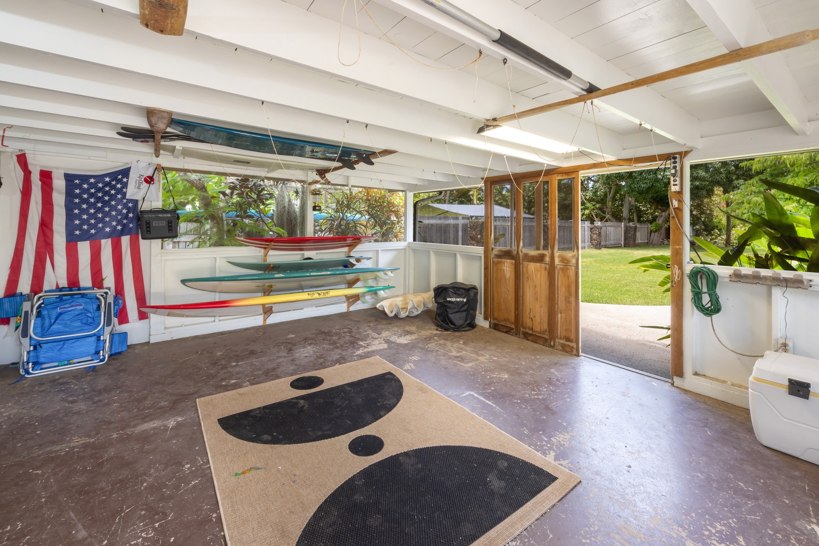 Kahuku Vacation Rentals, Hale Pellicano - This spacious garage offers convenient storage for surfboards and beach gear, with easy access to the backyard for outdoor adventures.