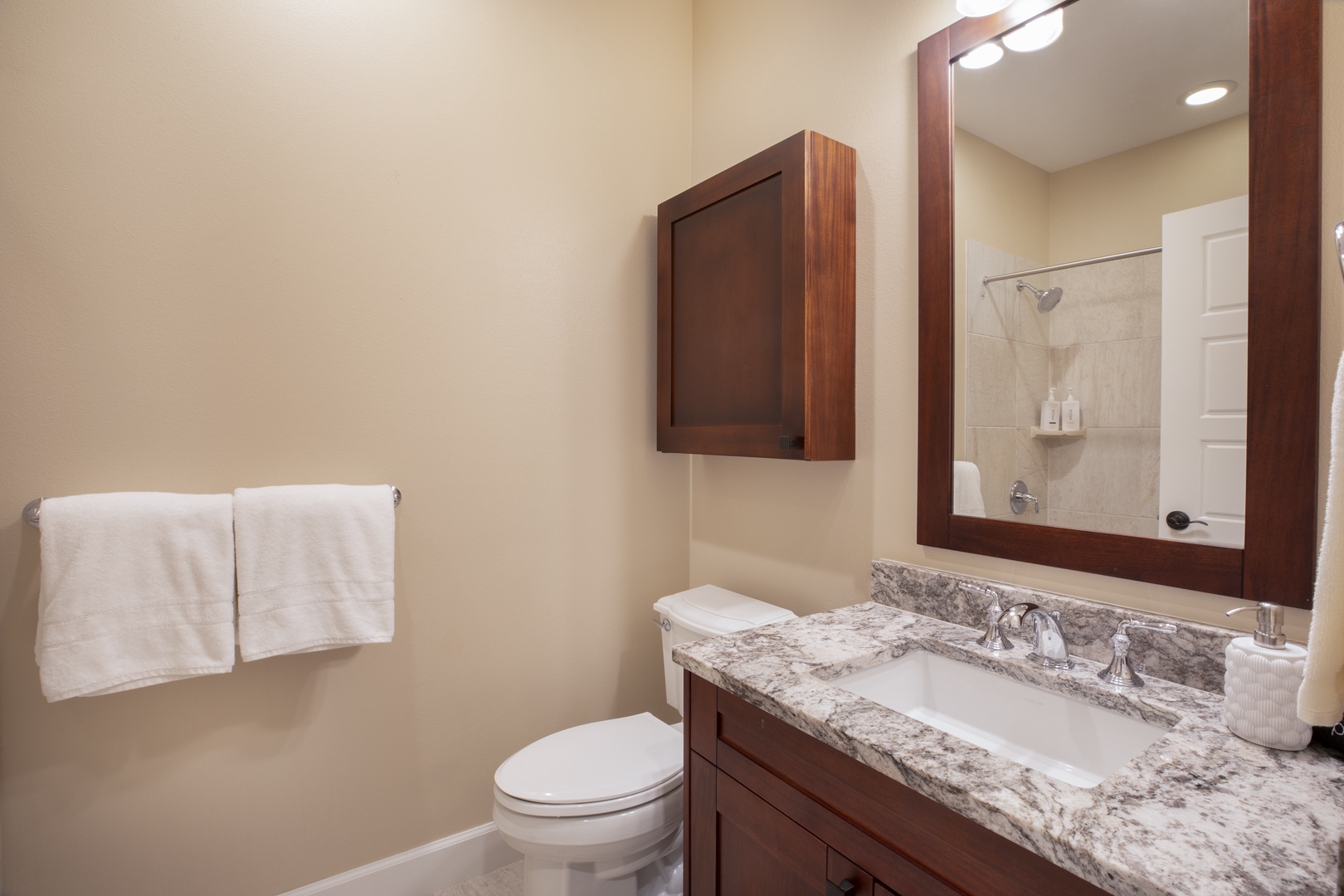 Kamuela Vacation Rentals, Mauna Lani KaMilo #503 - This well-appointed bathroom provides stylish convenience with warm wood finishes and granite countertops.