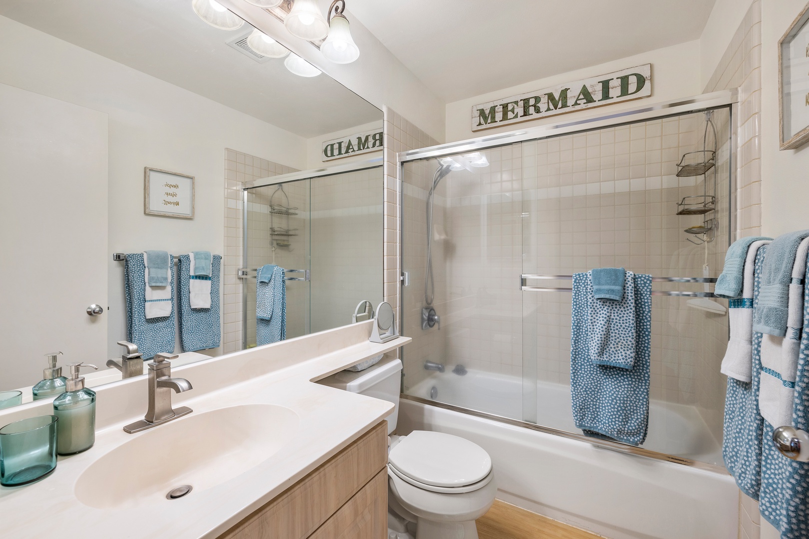 Step into your charming coastal bathroom where ocean-blue towels and nautical touches create a relaxing seaside retreat for your morning routine.