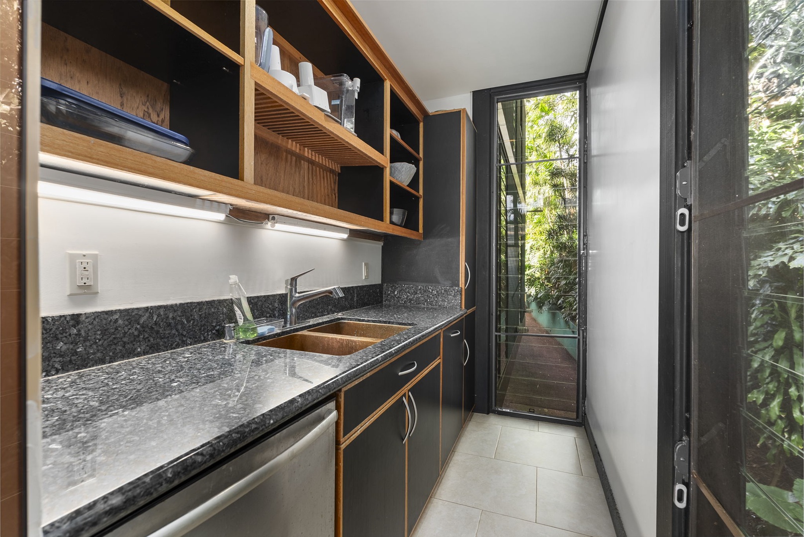 Honolulu Vacation Rentals, Tantalus Glass House (3 BD) - Cook with ease in this sleek modern kitchen featuring granite counters, wood cabinetry, and garden views through sliding doors.