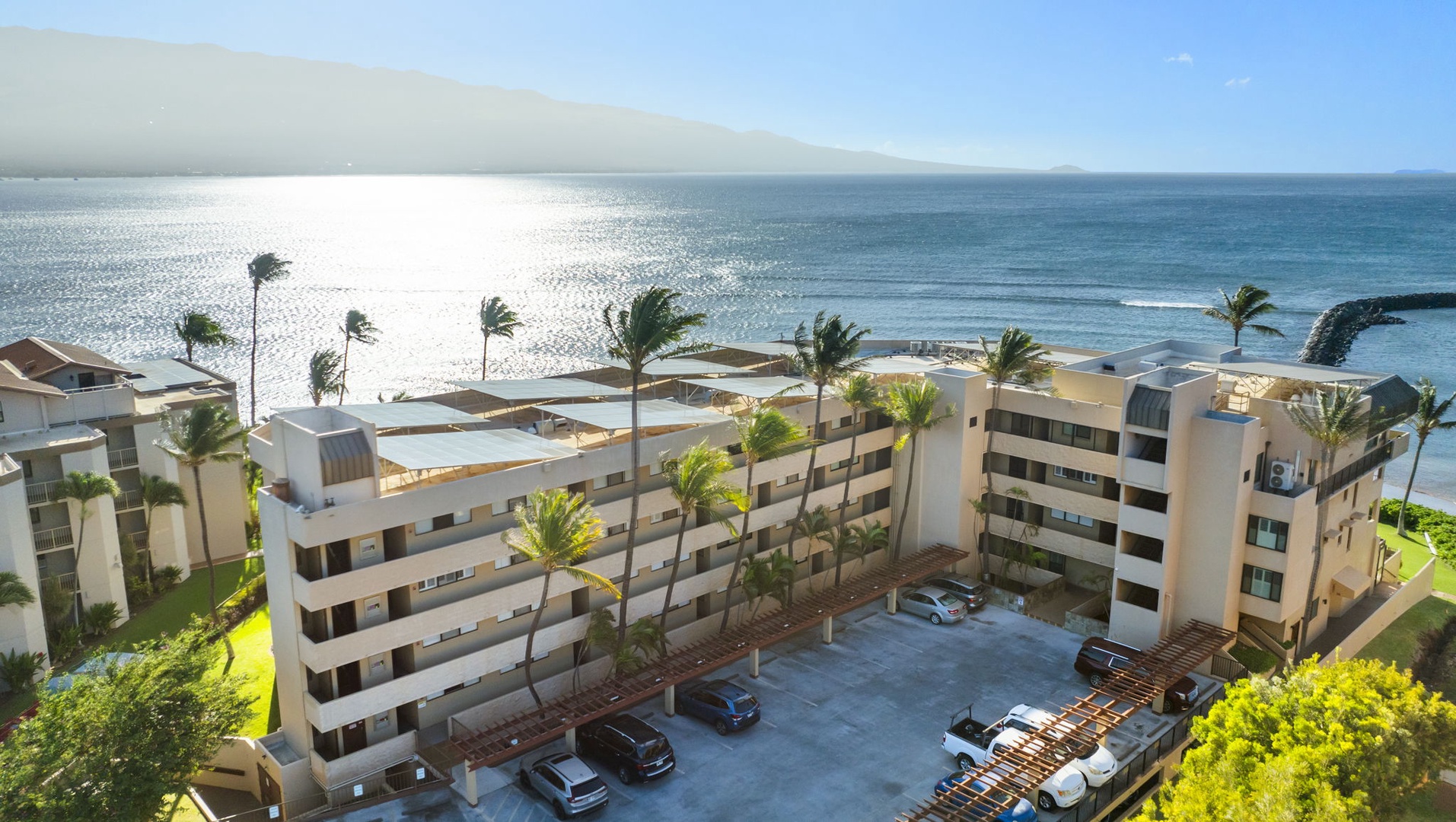 Wailuku Vacation Rentals, Milowai 310 - From above, Milowai's rooftop solar panels and parking pergolas fill the space between the road and the rocky shoreline below.