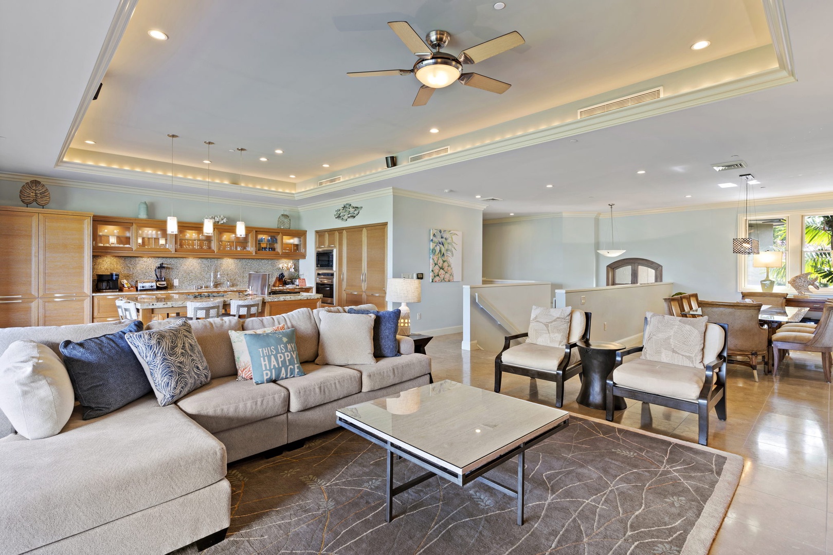 Wailea Vacation Rentals, Wailea Luxury Residence Hoolei 93-3 - Spacious living area with a plush sectional sofa, modern ceiling fan, and open layout that flows into the kitchen, creating a perfect spot for relaxation and gathering.