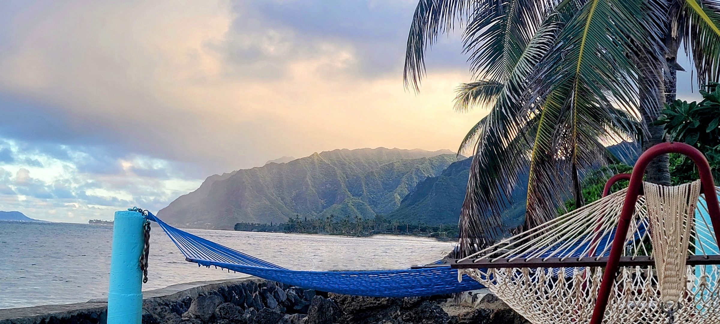 Hauula Vacation Rentals, Private Beach Paradise - The lawn ends at the water, one hammock swinging as the light goes.