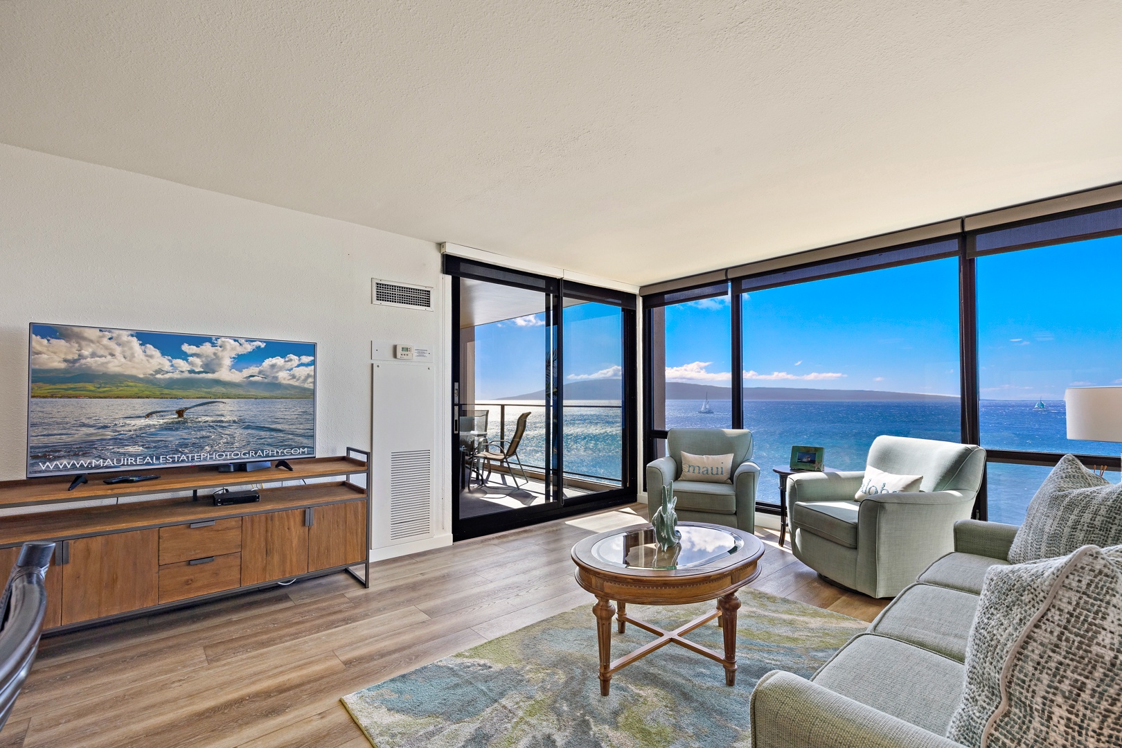 Lahaina Vacation Rentals, Mahana 718 - The living room features expansive ocean views, complemented by comfortable seating and a sleek entertainment center, perfect for unwinding after a day of island adventures.