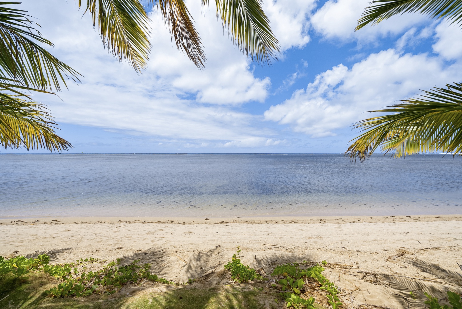 Honolulu Vacation Rentals, Honolulu Beachfront Retreat - Stunning beachfront with clear blue skies and calm ocean waves.