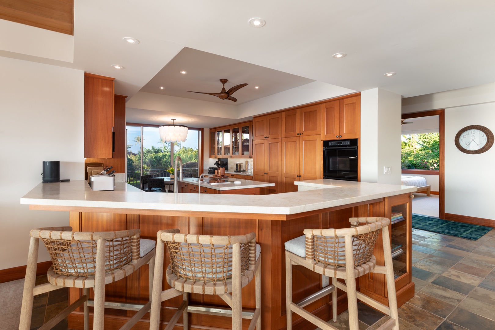 Kailua Kona Vacation Rentals, 3BD Waiulu Villa (111D) at Hualalai Resort - Your spacious kitchen invites culinary adventures with warm wood cabinetry, marble countertops, and island seating for memorable meals together.