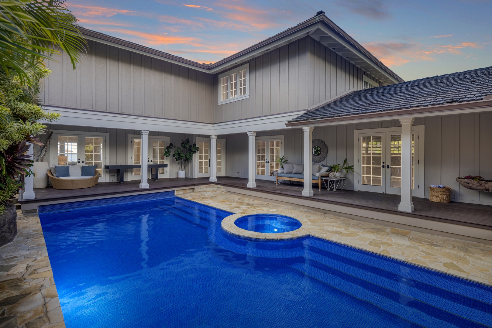 Honolulu Vacation Rentals, Moana Lani - Main House - The courtyard at twilight, the pool glowing blue against the lit-up house.