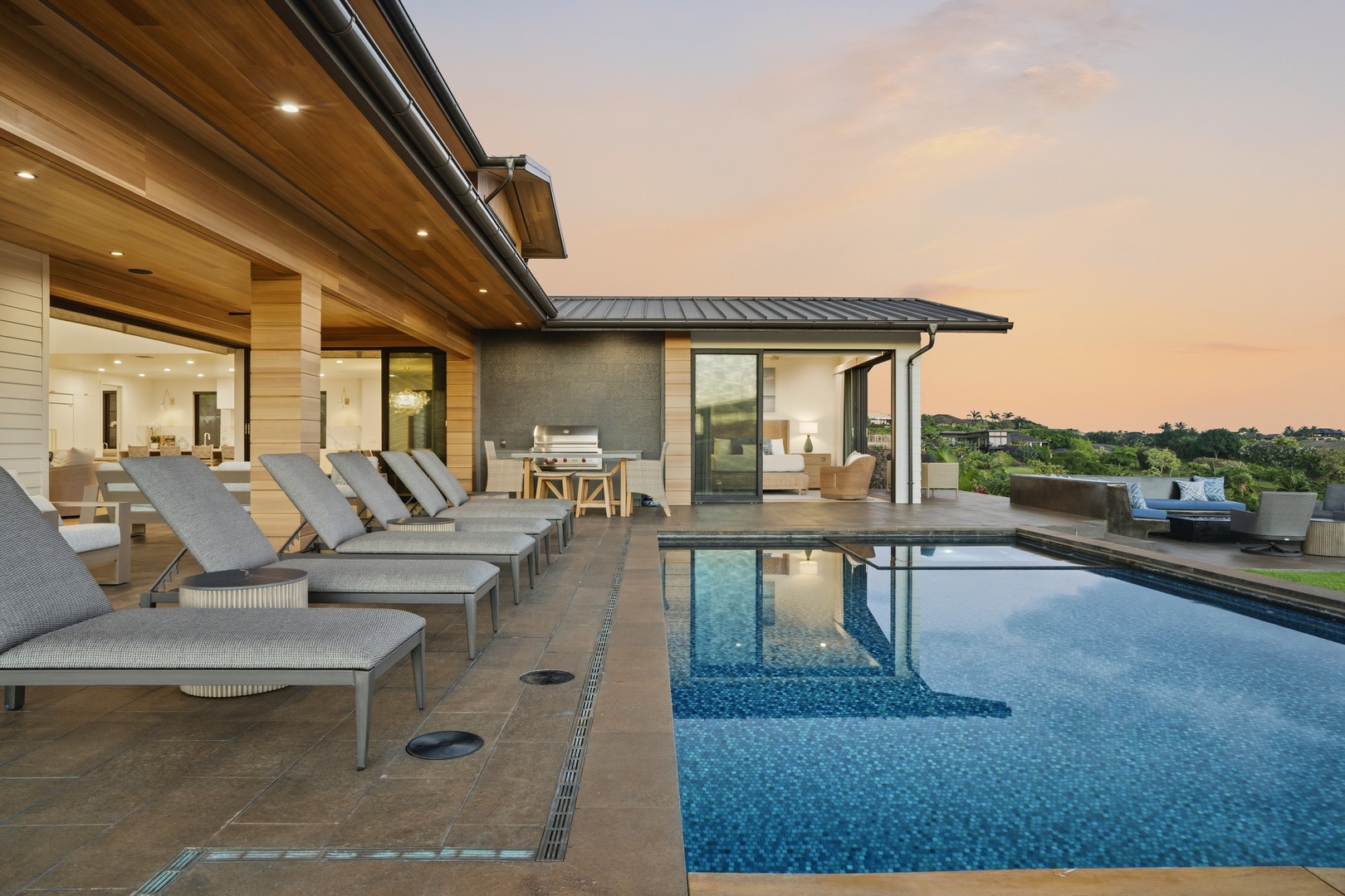 Koloa Vacation Rentals, Hale Laule'a at Kukui'ula - Modern luxury villa with infinity pool overlooking rolling hills, captured during golden hour with warm evening light.