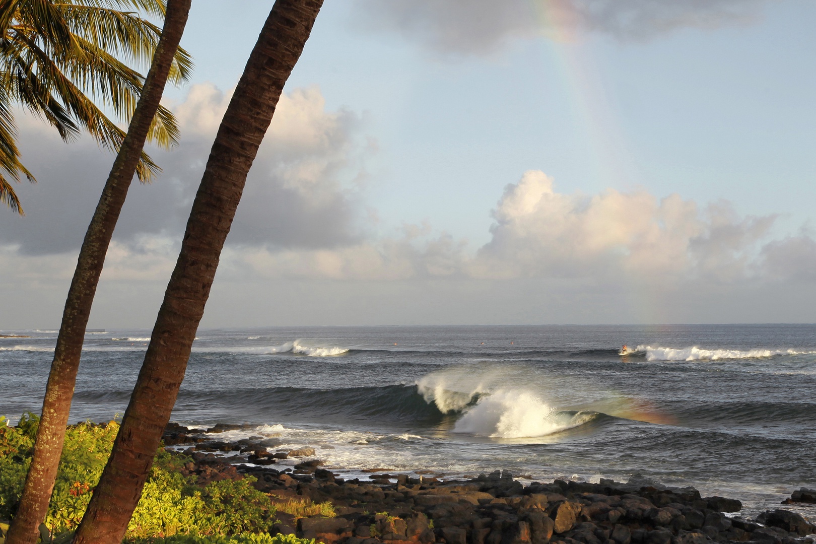 Koloa Vacation Rentals, Hiki Moe Hale - Surfers catching waves along the picturesque Lawai Road shoreline.