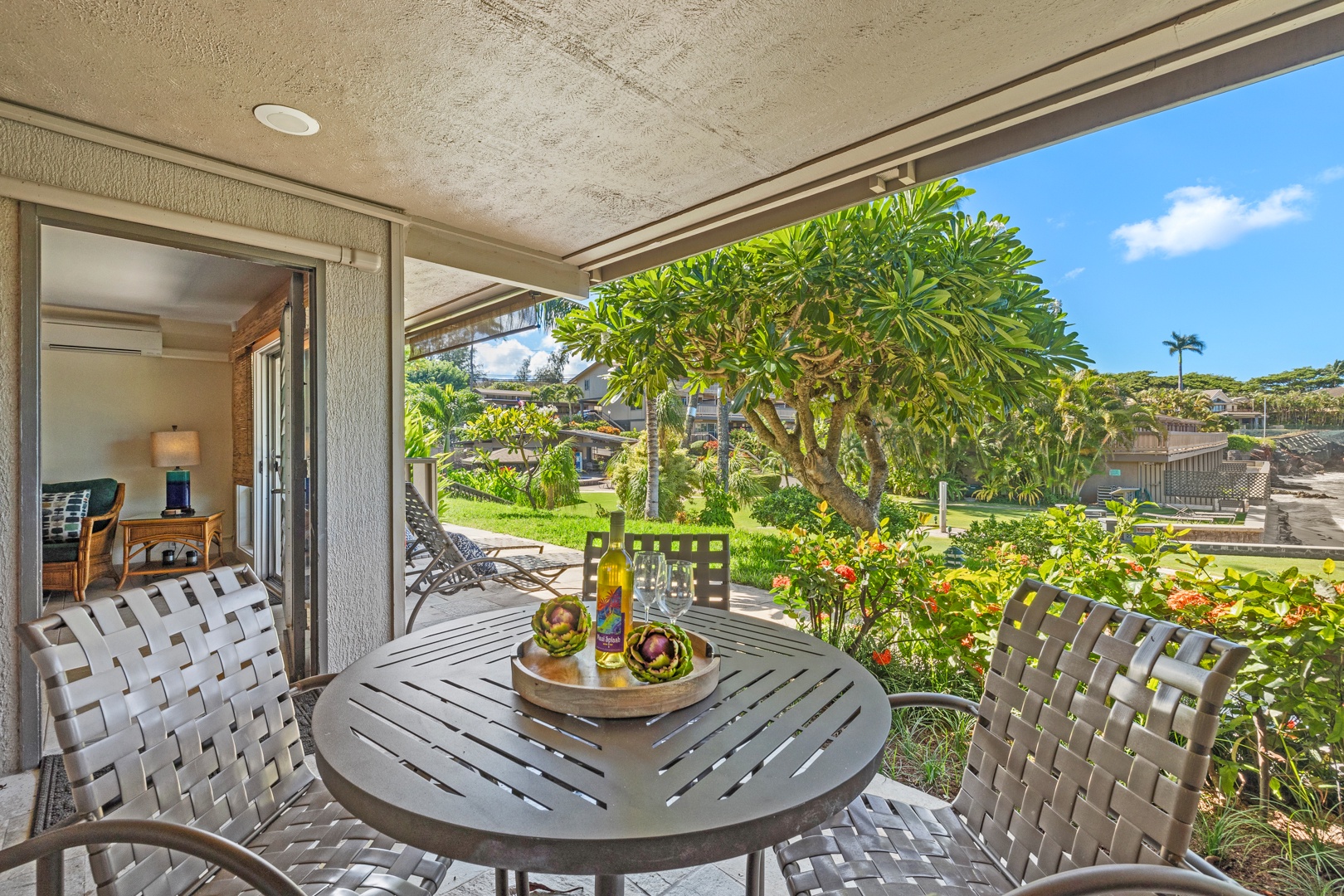 Lahaina Vacation Rentals, Kahana Sunset B4B - The shaded lanai offers a lovely outdoor dining space with beautiful garden views, perfect for enjoying meals or relaxing in the fresh island air.