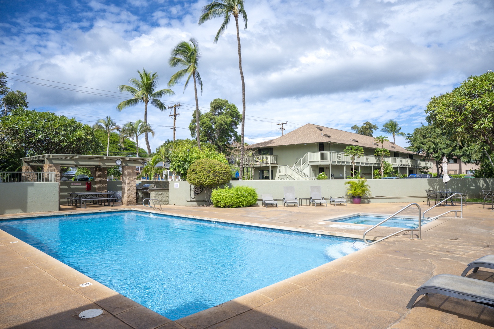 Kihei Vacation Rentals, Kihei Bay Surf B212 - This beautiful tropical resort features a sparkling swimming pool surrounded by lush palm trees and comfortable poolside loungers for the perfect Hawaiian getaway.