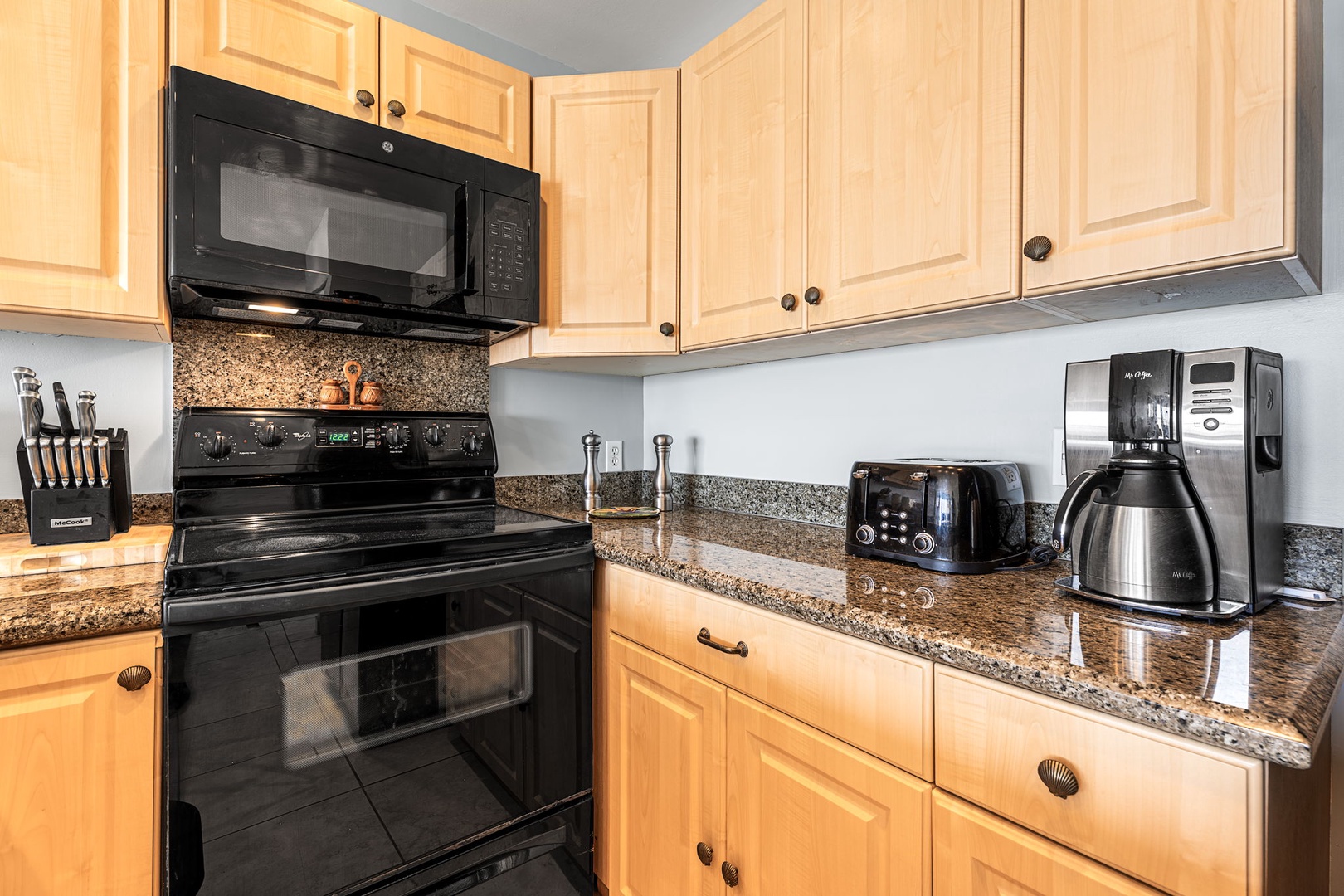 Kailua Kona Vacation Rentals, Sea Village 1105 - Modern black appliances and natural wood cabinets blend convenience with island charm.