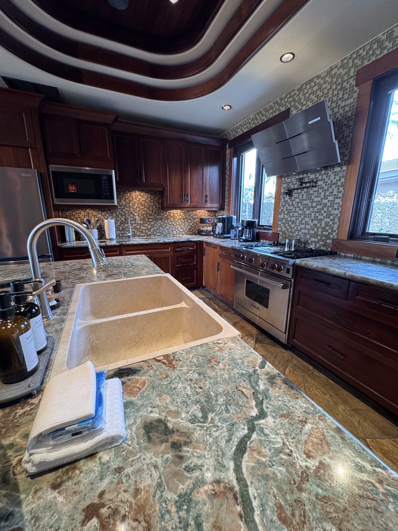 Kamuela Vacation Rentals, Hale Konane - A chef’s dream kitchen featuring rich wood finishes and high-end countertops.