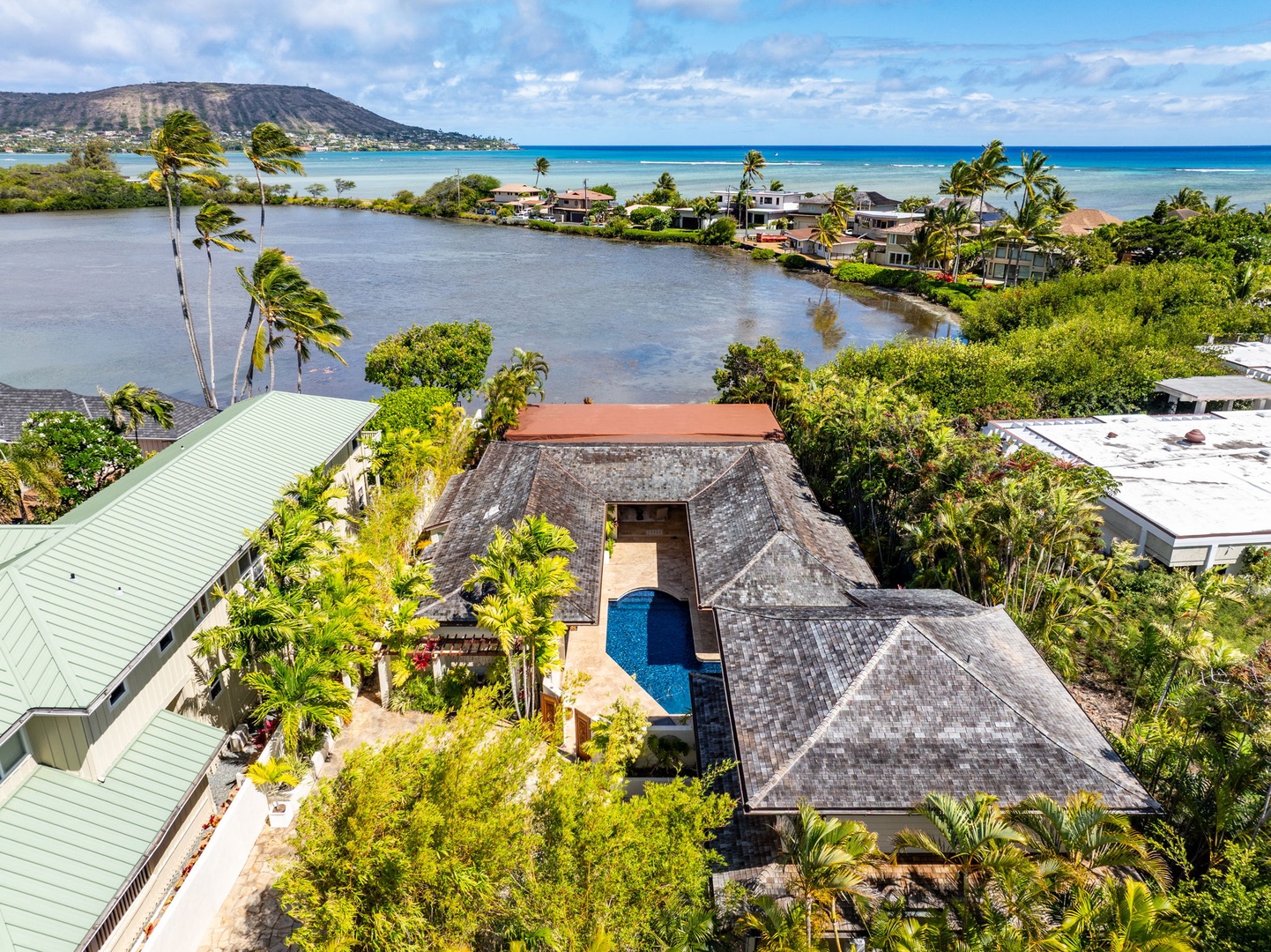 Honolulu Vacation Rentals, The Lagoon House 3BR - Waterfront setting where lagoon waters meet the open ocean, framed by swaying palms.