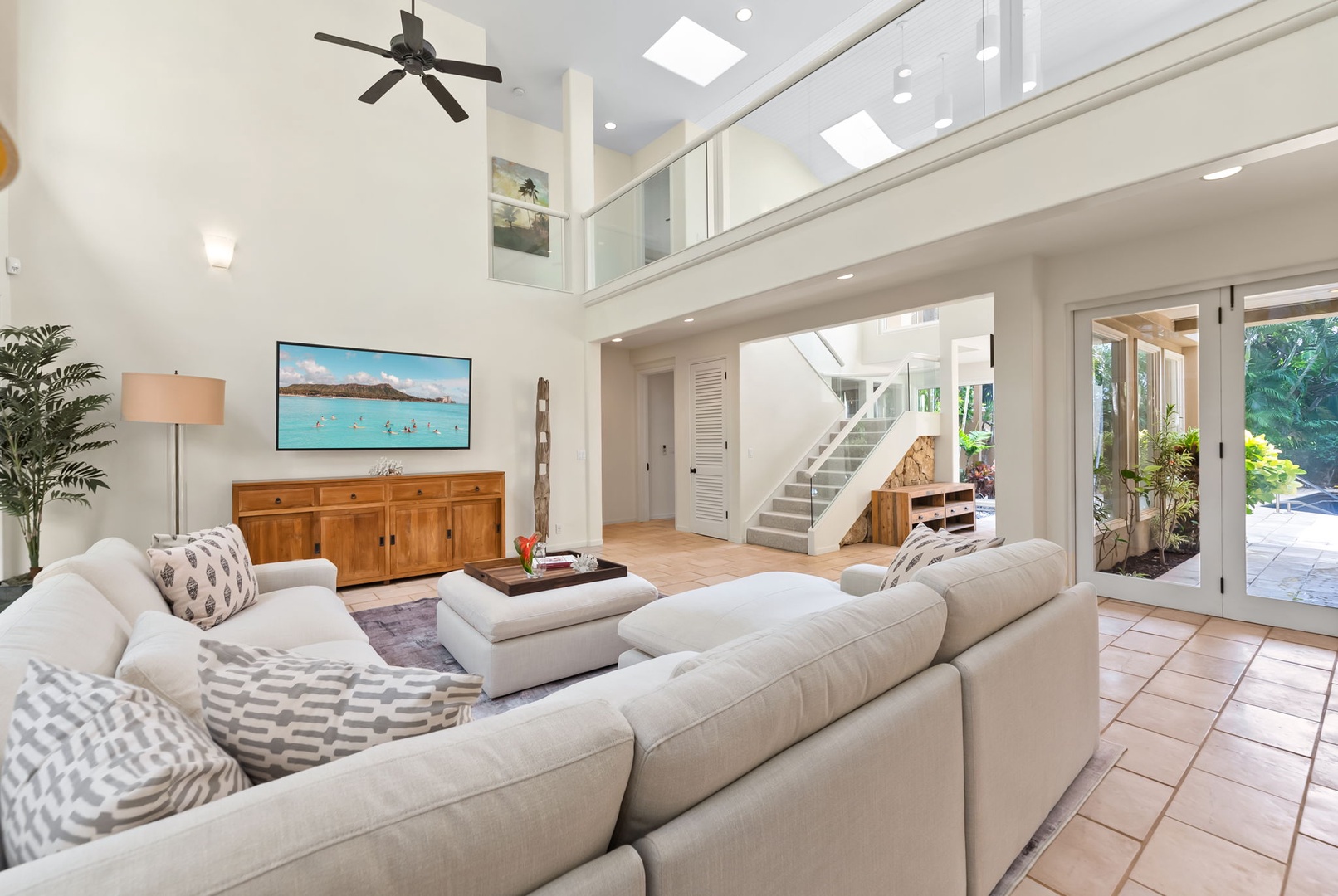 Honolulu Vacation Rentals, Diamond Head Luxe - Bright, airy living room with soaring ceilings, comfortable sectional seating, and French doors opening to lush gardens.