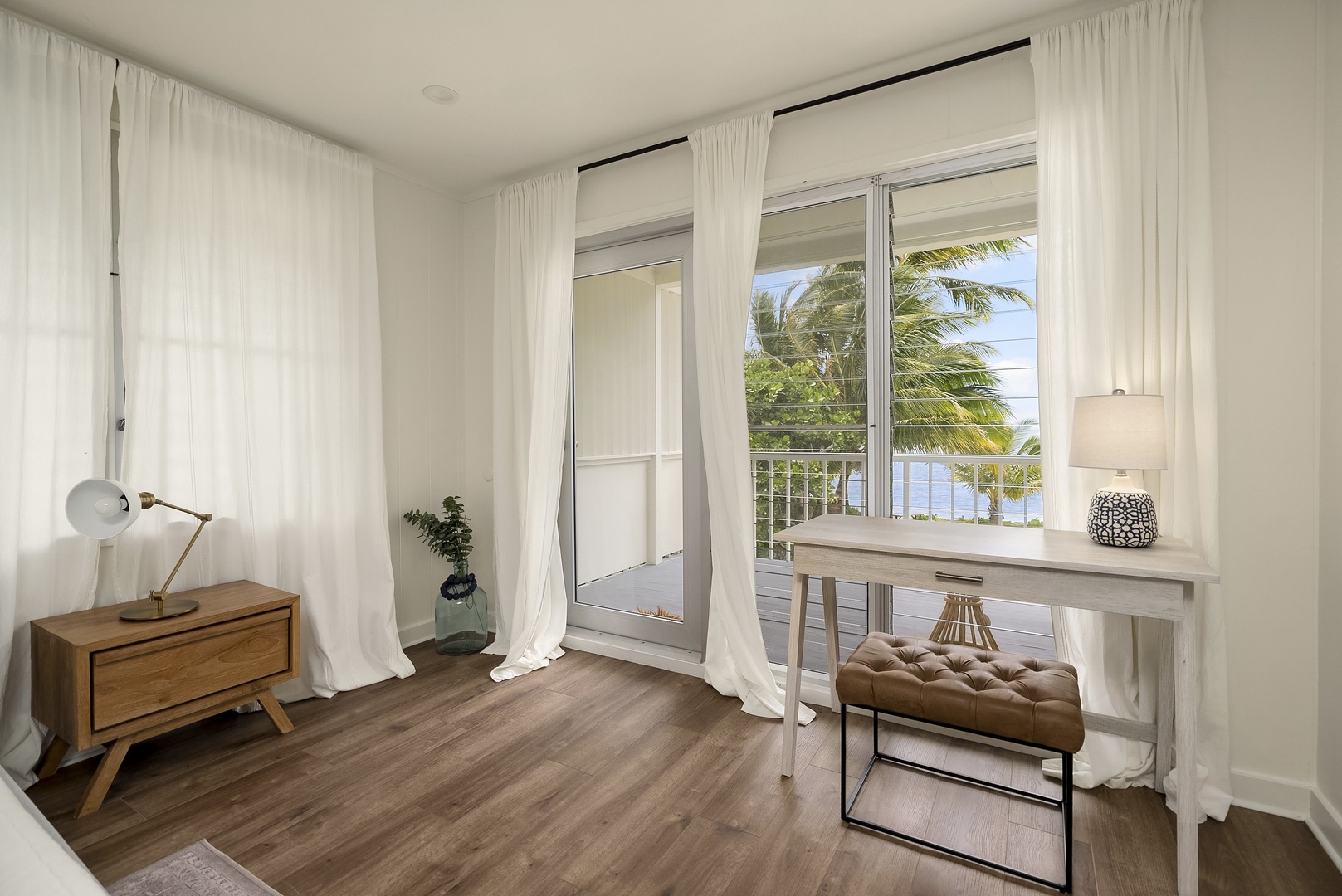 Honolulu Vacation Rentals, Honolulu Beachfront Retreat - Bright and airy bedroom corner with a writing desk, offering views of the balcony and lush surroundings.