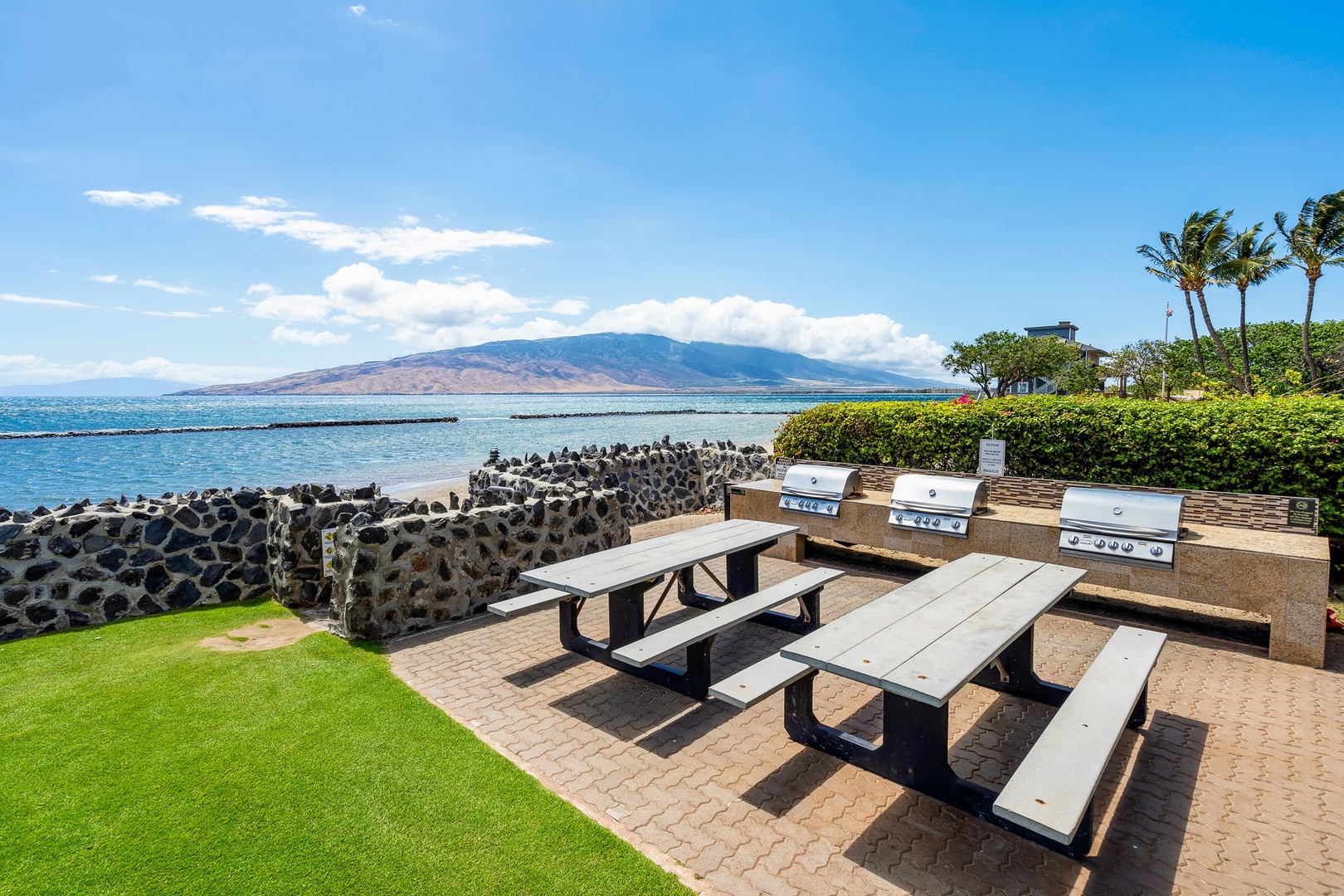 Kihei Vacation Rentals, Menehune Shores 316 - Stainless grills and picnic tables face the seawall, dinner with West Maui's mountains across the water.