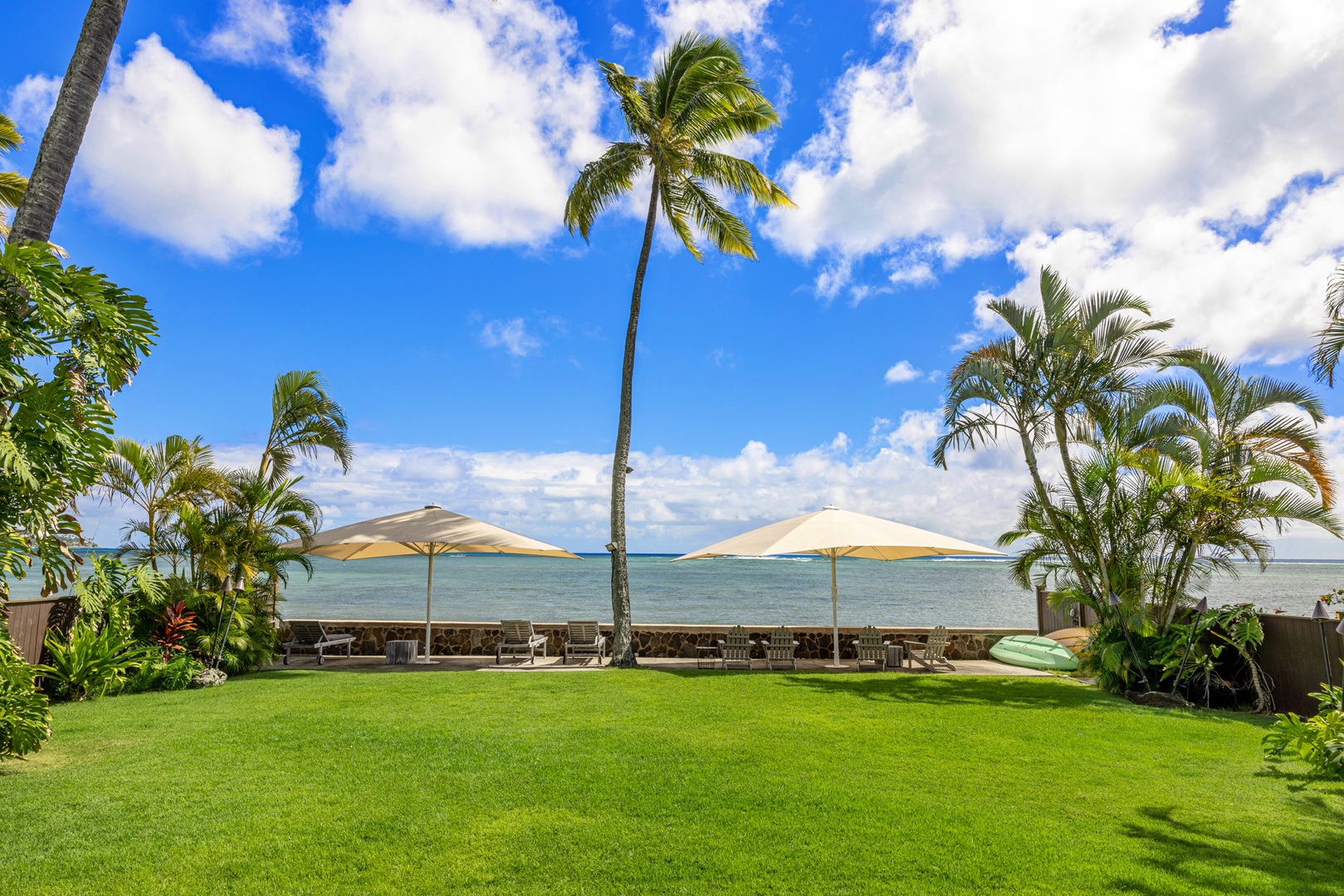 Honolulu Vacation Rentals, Moana Lani - Expansive lawn leading straight to the shoreline, framed by swaying palms.
