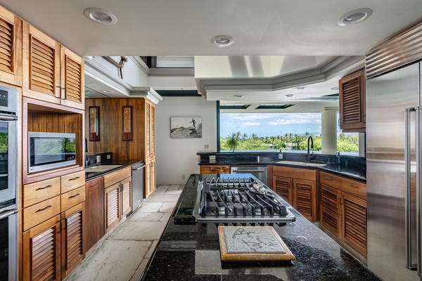 Kamuela Vacation Rentals, Canoe House & Beach Walker at Champion Ridge - Modern kitchen with a spacious island, gas stove, and scenic views, perfect for preparing meals.