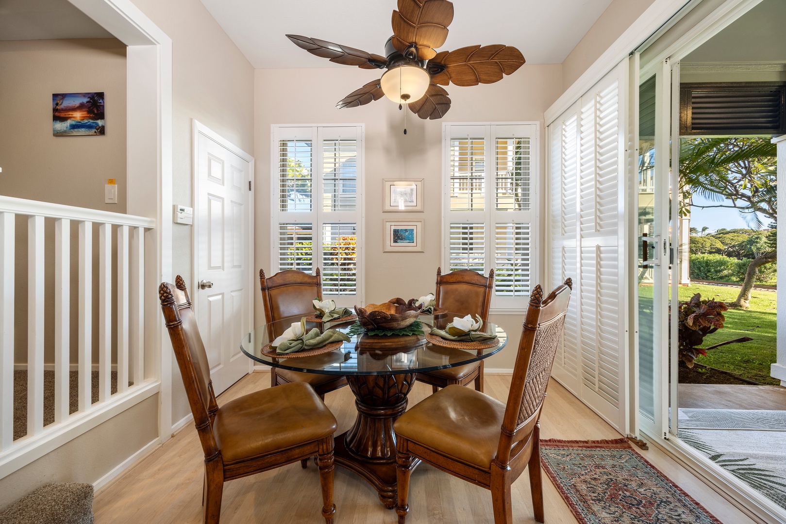 Gather around this elegant glass dining table where tropical breezes flow through open doors to your private garden oasis.