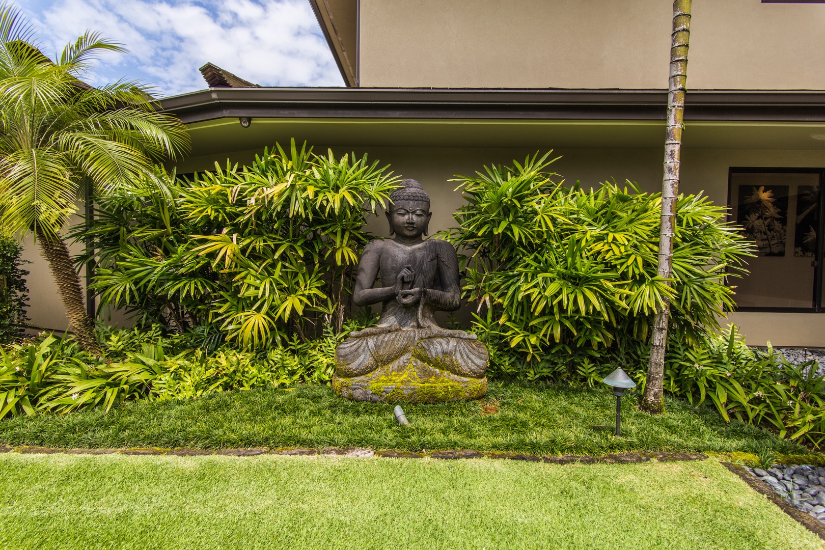 Princeville Vacation Rentals, Hanalei Plantation Villa - Peaceful garden setting with a Buddha statue, adding a touch of serenity to the lush surroundings.