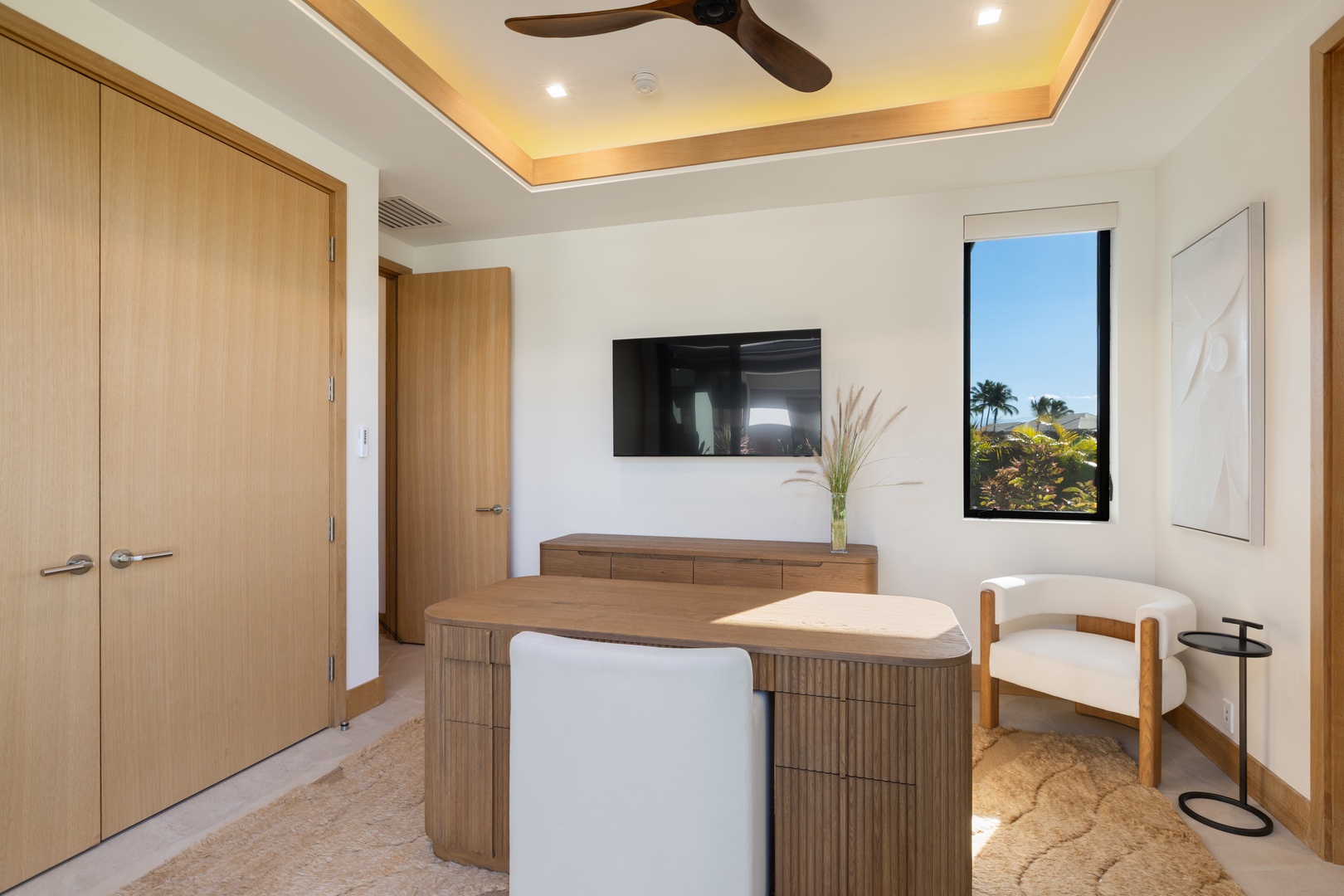 Kamuela Vacation Rentals, 5BD Mauna Lani Lux Ocean Estate (OE12) at One Ocean - Your private workspace features warm wood accents and a wall-mounted TV, with tropical views through your window.