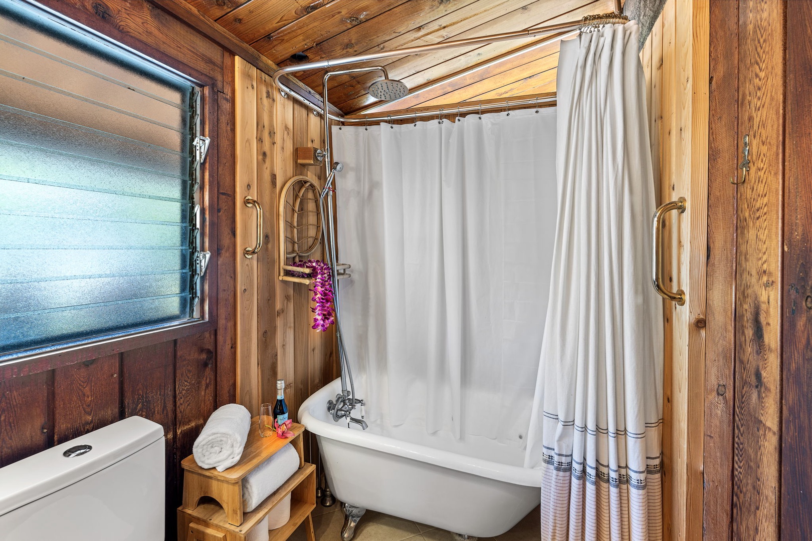 Kailua Kona Vacation Rentals, Mai Tai Manor - Soak in your vintage clawfoot tub surrounded by rich wood paneling—a charming rustic bathroom where luxury meets mountain cabin charm.