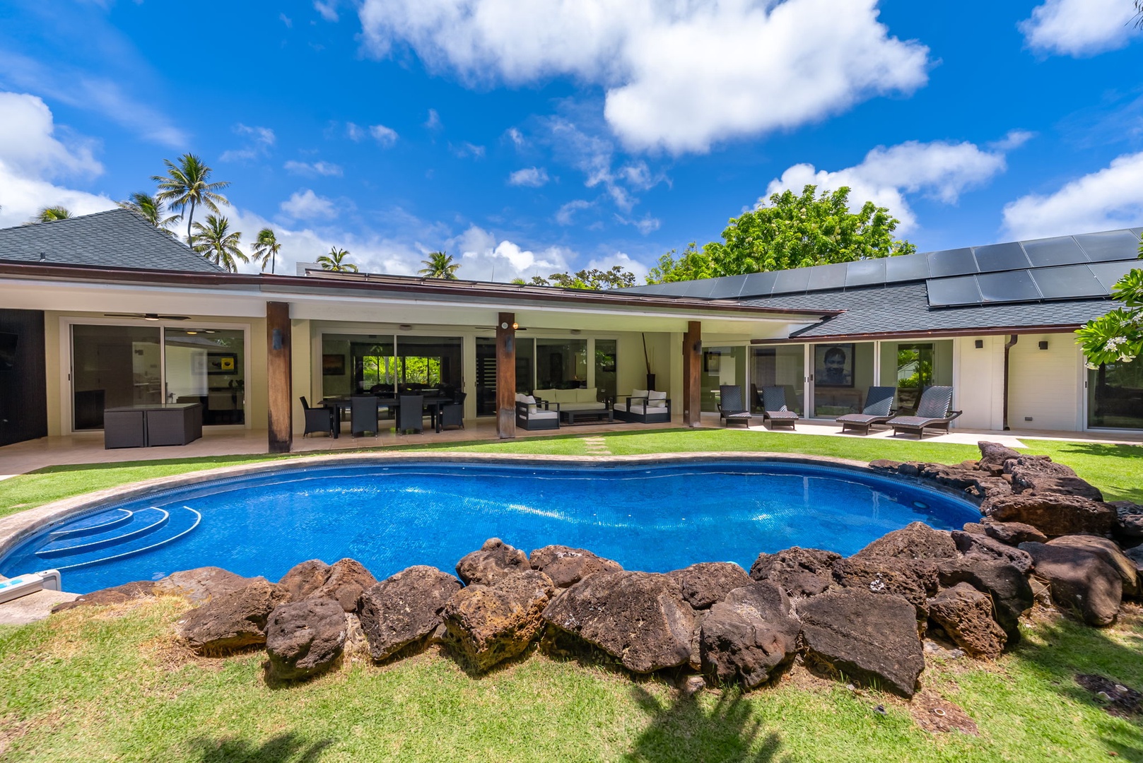 Honolulu Vacation Rentals, Kahala Lani - Wide view of the pool framed by the home’s open design and shaded lanais.