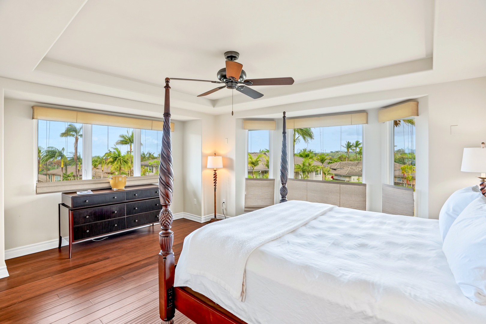 Princeville Vacation Rentals, Hale Hau'oli Moku - Primary suite mornings start with palm tops filling the bay windows beside the four-poster bed.