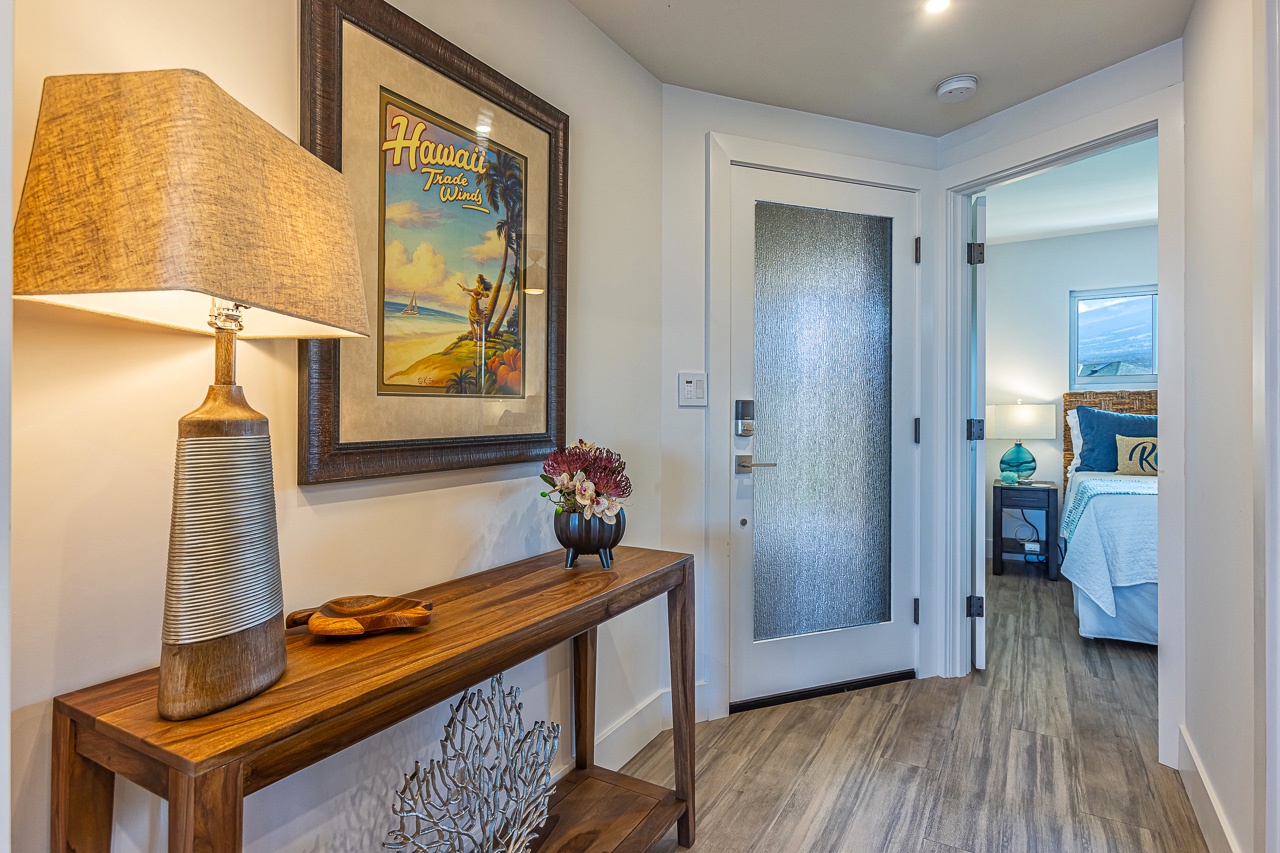 Kihei Vacation Rentals, Kamaole Beach Royal 610 - A console table and framed print welcome you in, with the primary suite just beyond the door.