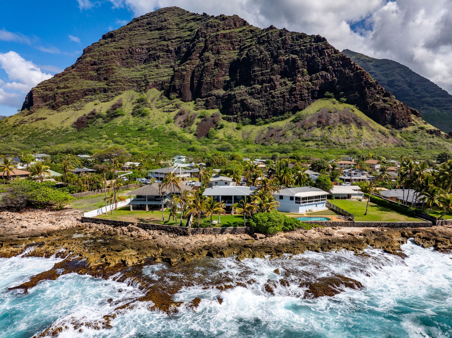 Waianae Vacation Rentals, Oceanfront Luxury Dream Estate - Aerial view shows the estate nestled between lush mountains and the dramatic Wai?anae coastline.