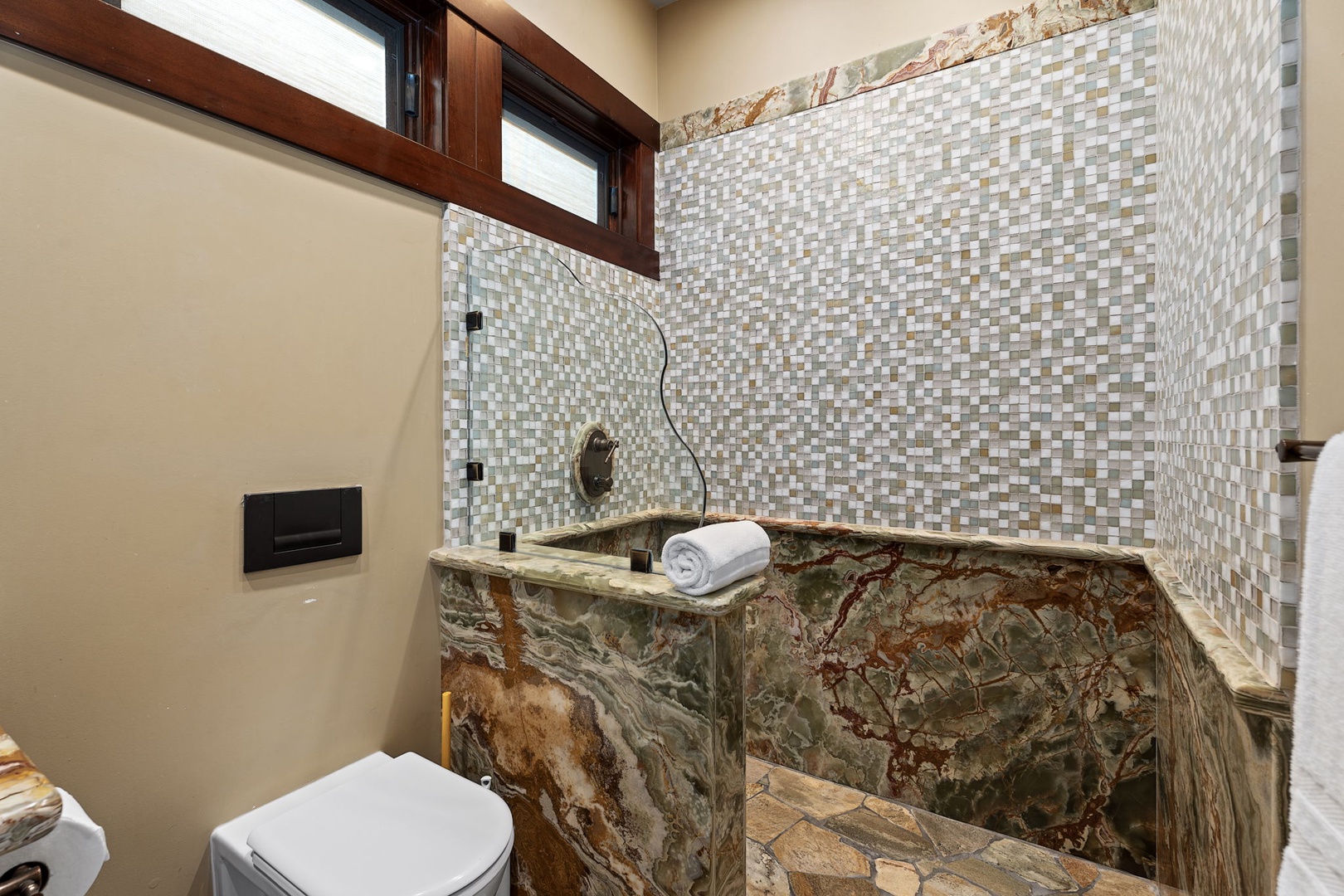 Kamuela Vacation Rentals, Hale Konane - Well-designed bathroom featuring a walk-in shower with natural stone and mosaic tile detail.
