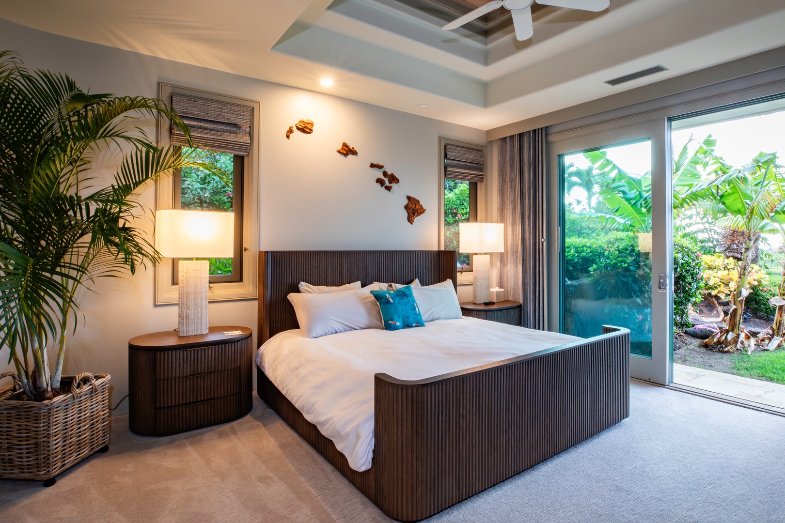 Kamuela Vacation Rentals, Canoe House at Champion Ridge - Spacious bedroom with a ceiling fan, modern furnishings, and large windows that open to a tropical view.