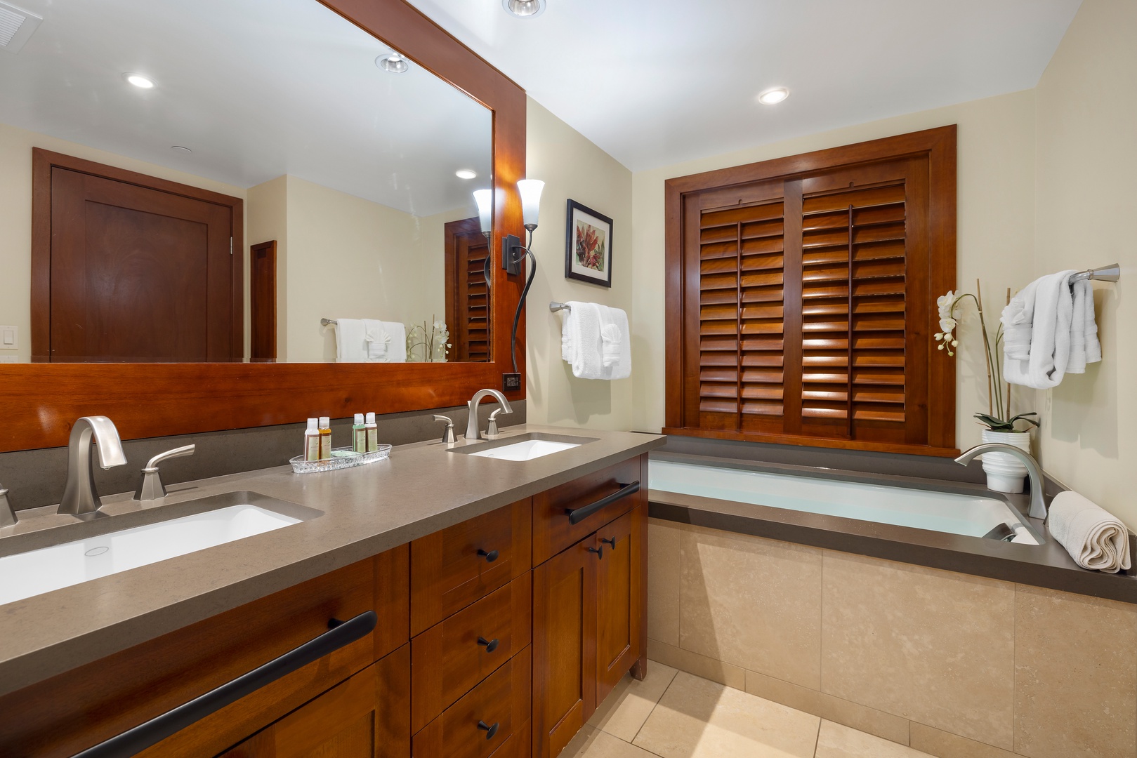 Kapolei Vacation Rentals, Ko Olina Beach Villas B901 - Unwind in your elegant bathroom featuring dual vanities, a deep soaking tub, and rich wood finishes that create a spa-like retreat.