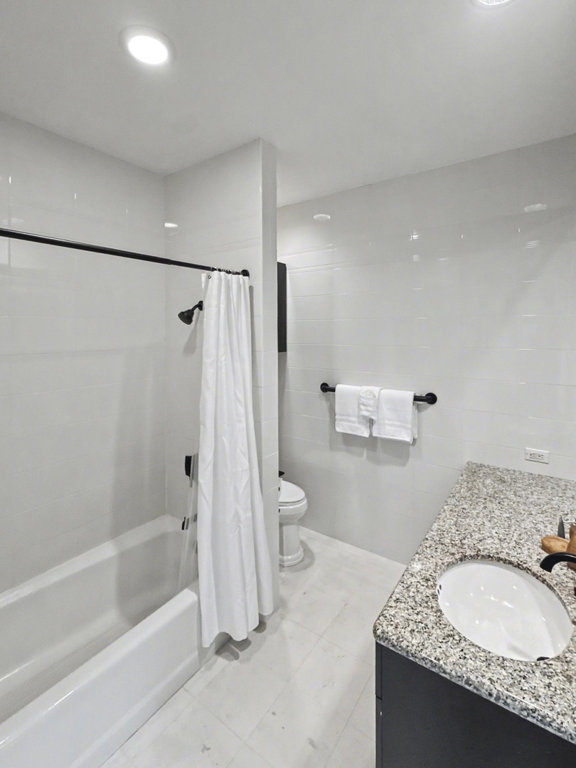 Kailua Kona Vacation Rentals, Hale Nai'a - Your pristine bathroom features a spacious tub-shower combo with granite countertops and fresh towels ready for your relaxing getaway.