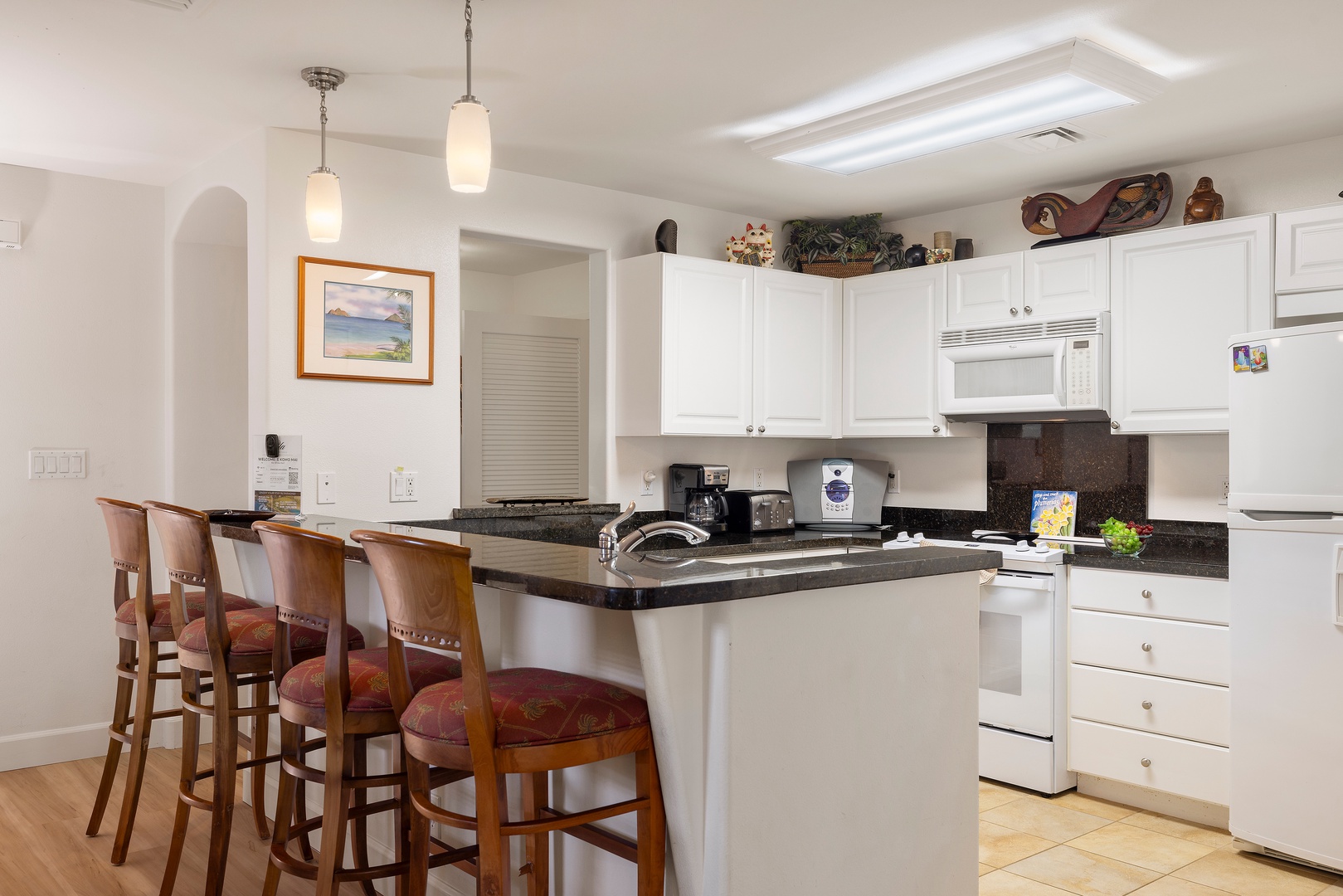 Kapolei Vacation Rentals, Ko Olina Kai 1105E - Gather at your open kitchen island with full appliances, sleek countertops, and breakfast bar seating—your home base for easy vacation meals and morning coffee before adventures begin.